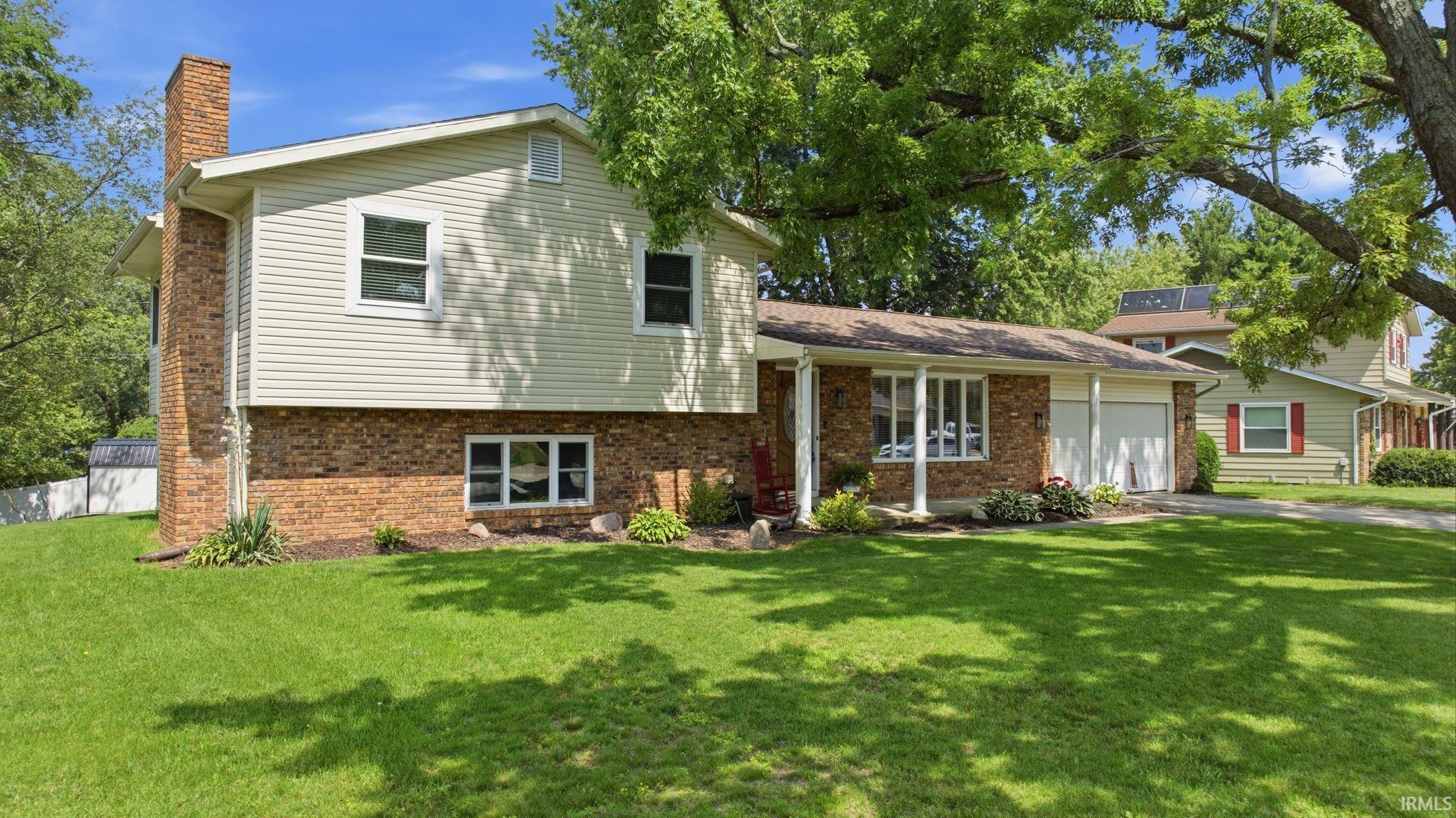 Brick and siding exterior featuring a prominent brick chimney