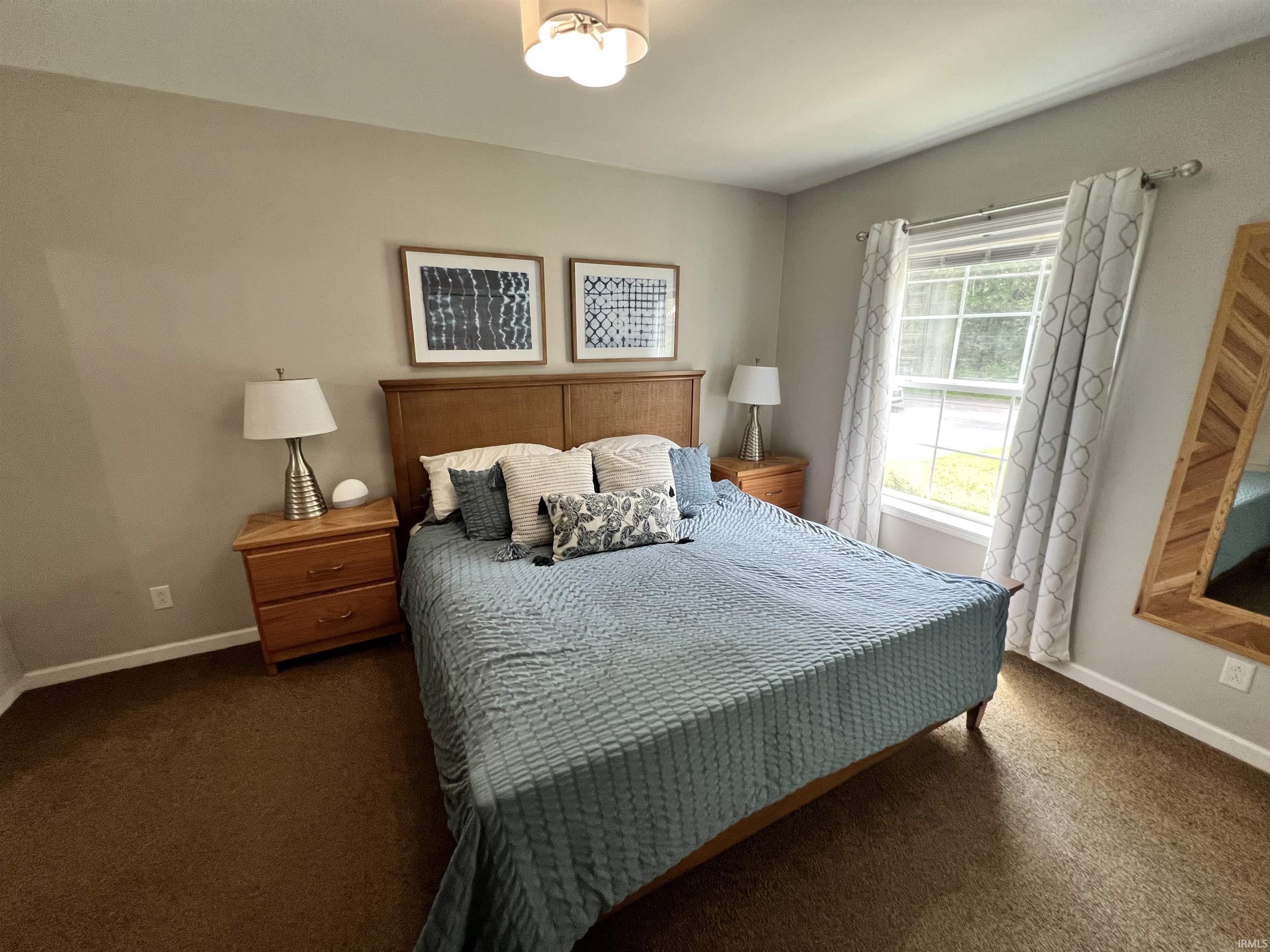 Bedroom featuring light brown wall paint and dark brown carpet flooring