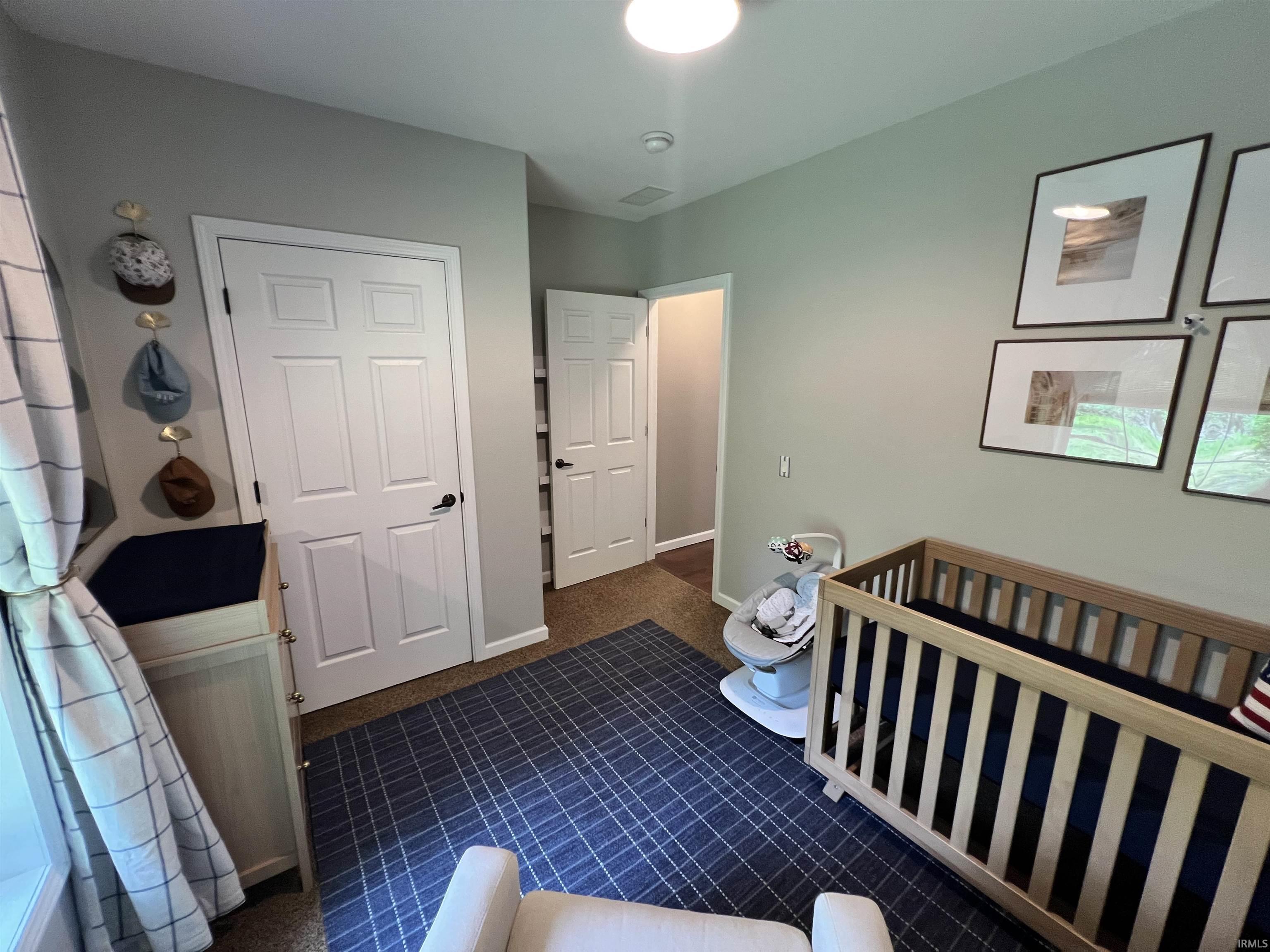 Neutral-toned interior room featuring carpeted flooring and light grey wall paint