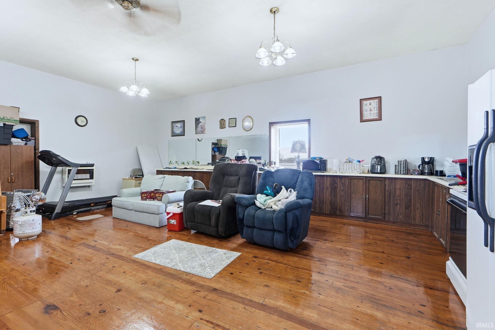 Expansive room featuring wood-finish flooring, a ceiling fan, and recessed lighting fixtures