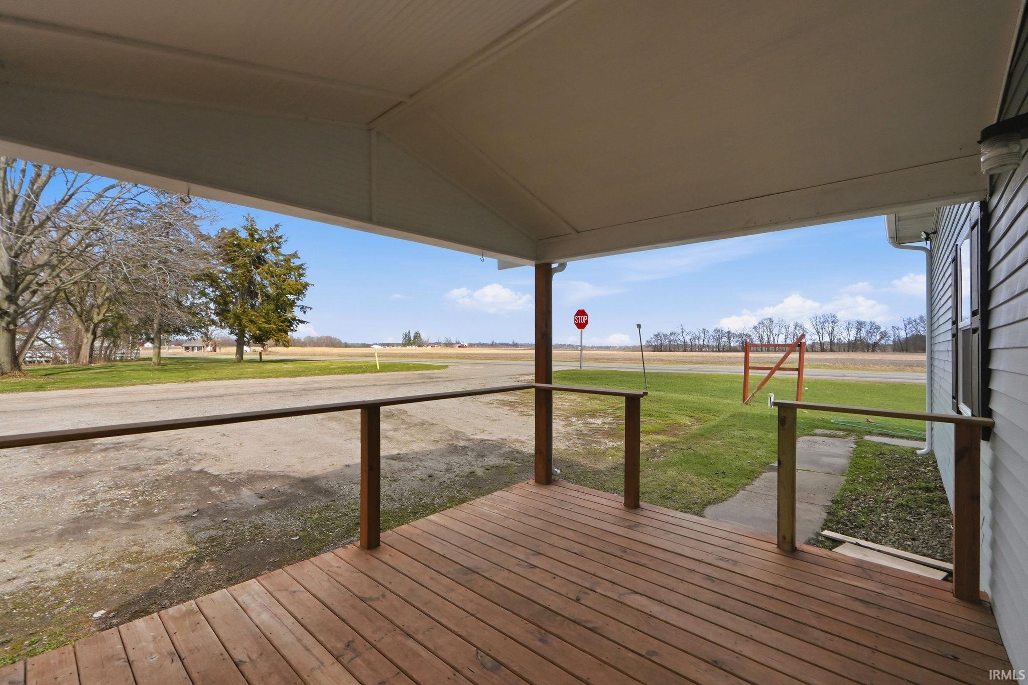 Covered porch featuring wood decking and wood railings