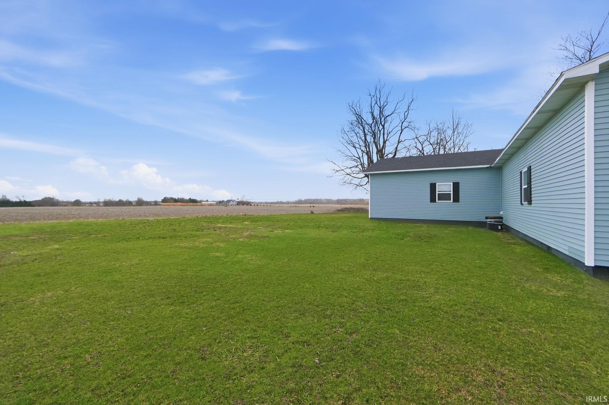 Expansive green lawn bordering a light blue siding exterior with white trim