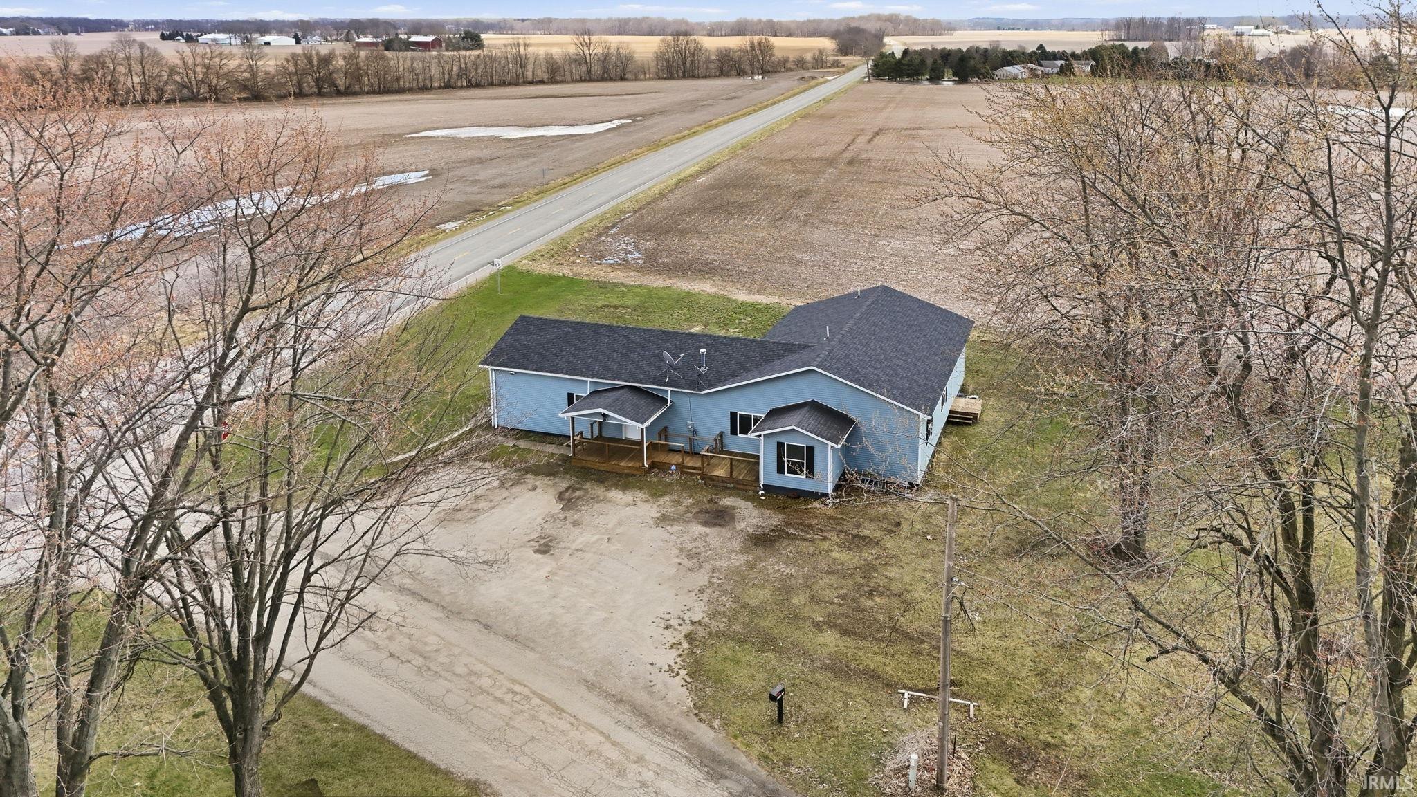 Ranch-style residence with light blue siding and a dark shingle roof