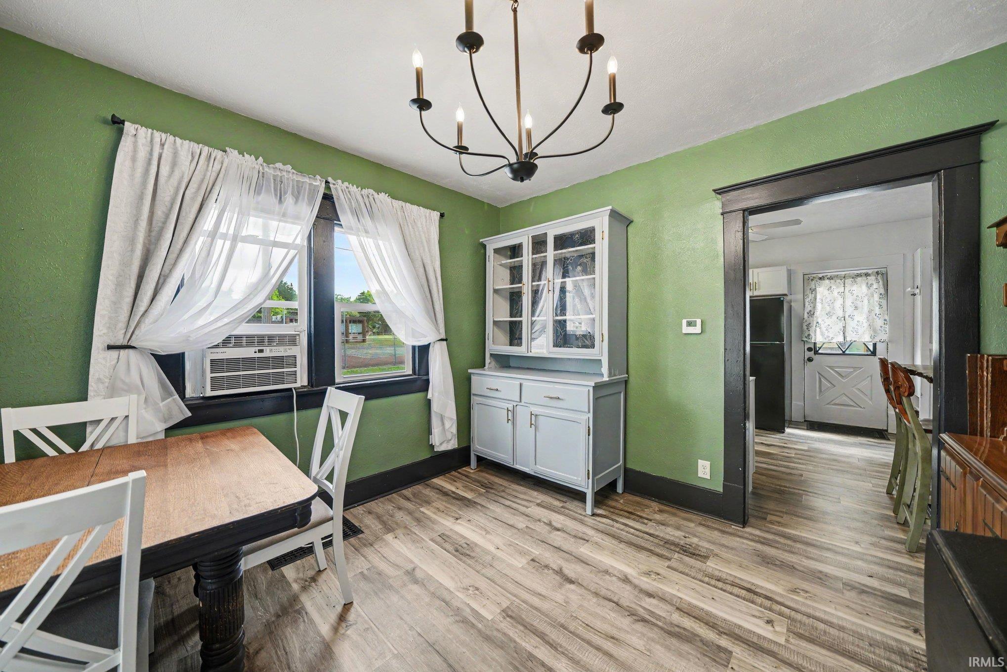 Dining area featuring wood-finish flooring and a central chandelier