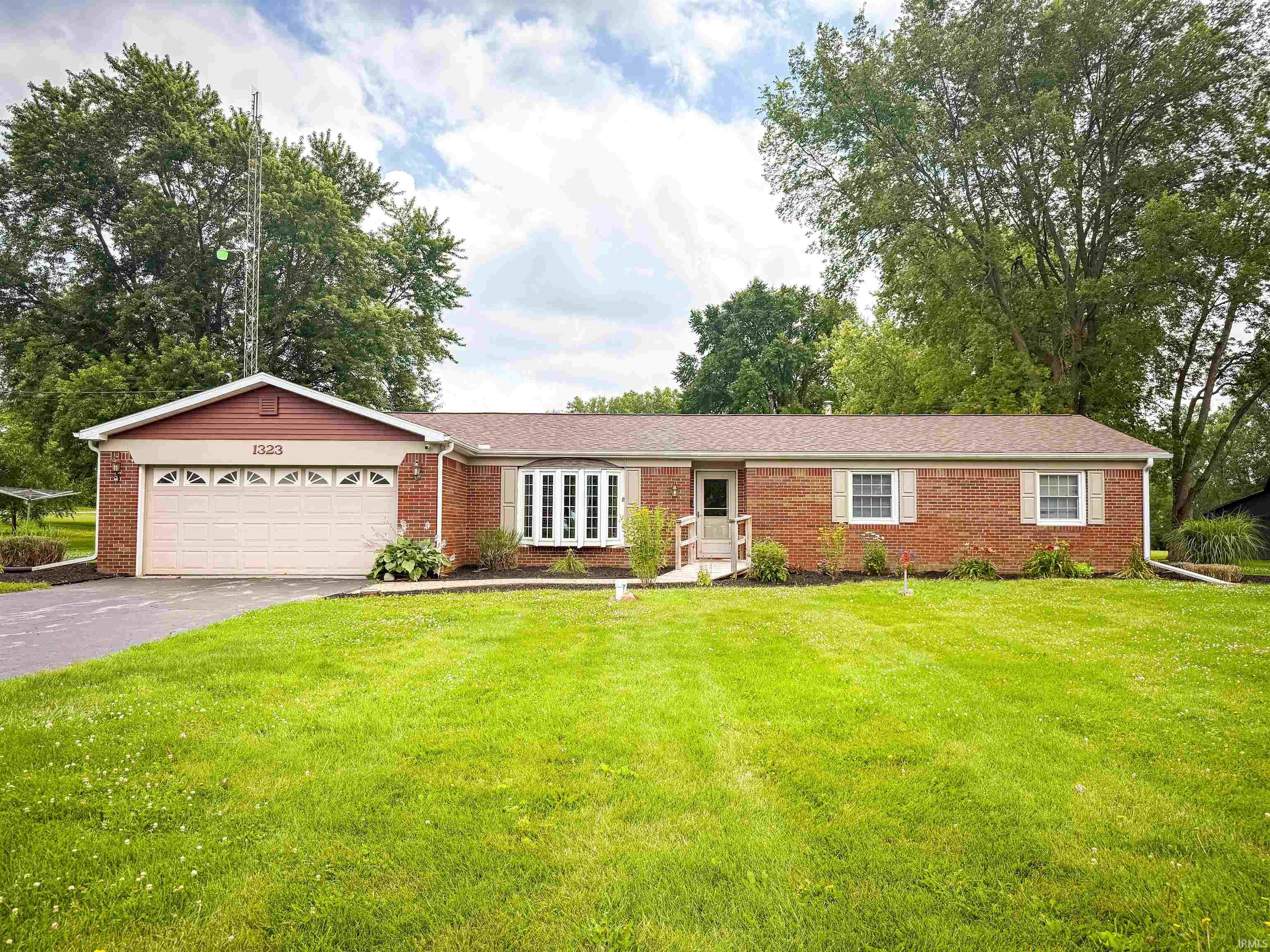 Brick ranch-style residence featuring an attached garage with an asphalt driveway