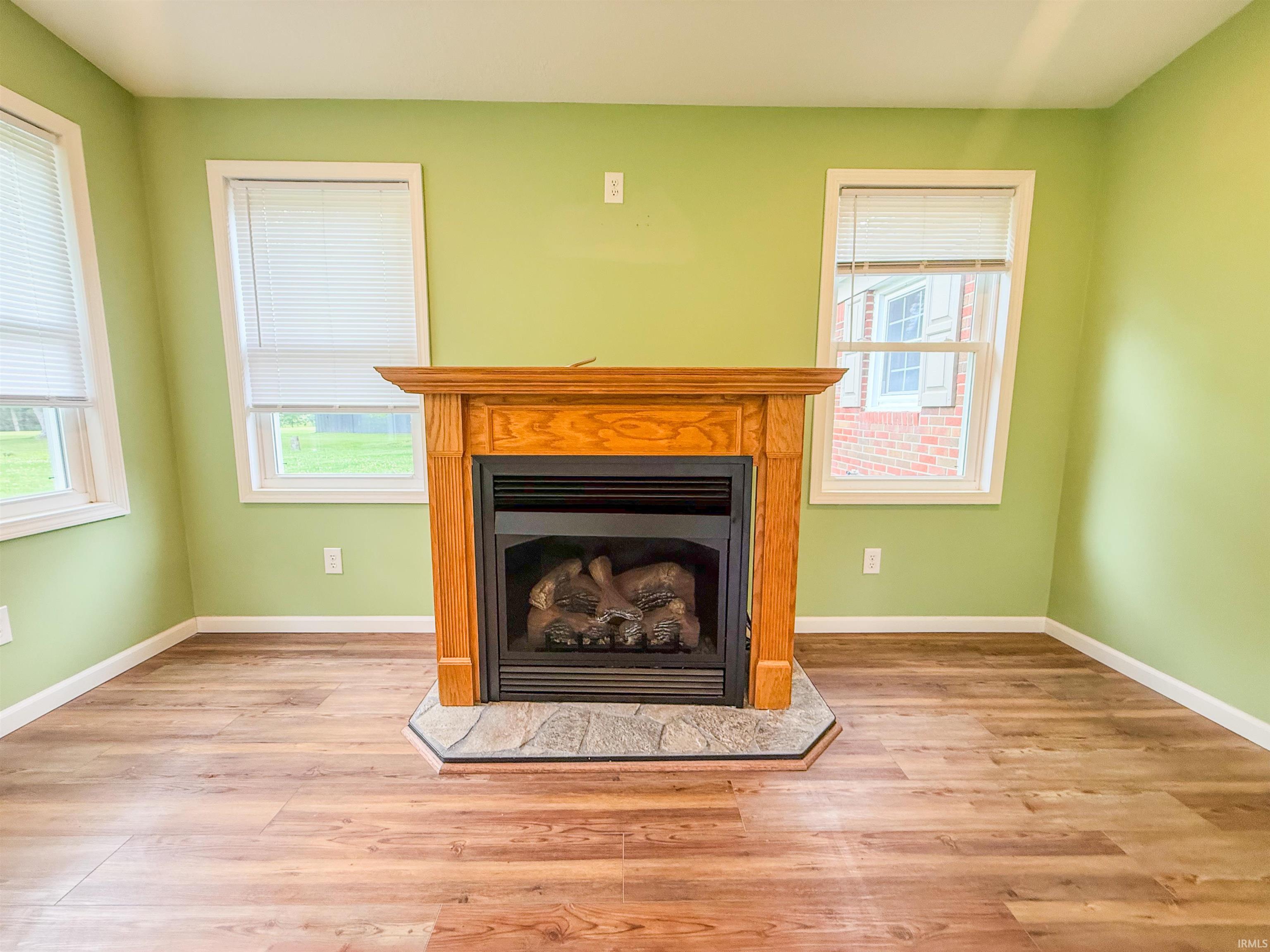 Central fireplace with a wood mantel and a natural stone hearth