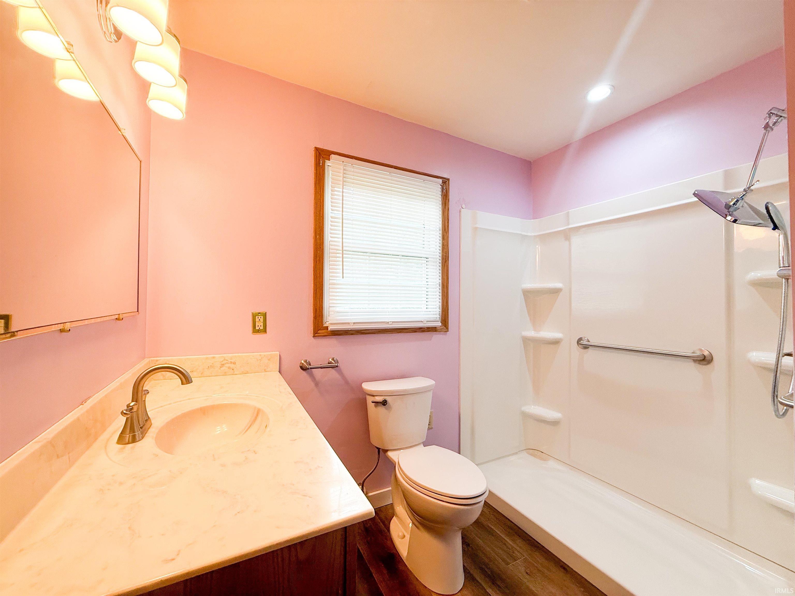 Bathroom featuring a vanity with an integrated sink, a brushed nickel faucet, and a large wall-mounted mirror