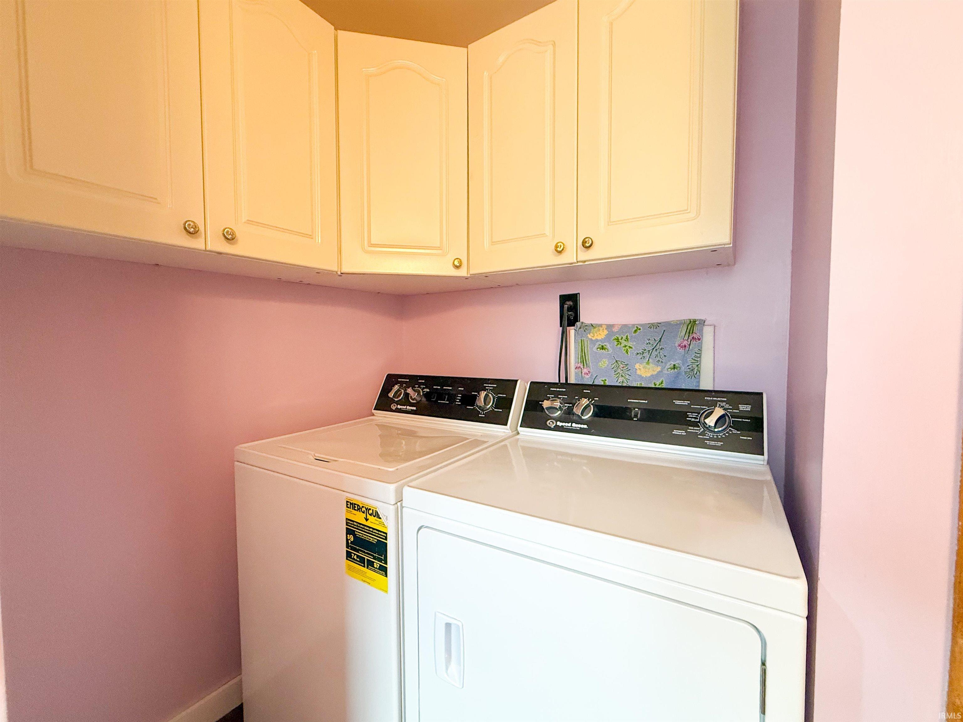 Corner utility space featuring upper cabinetry with brass hardware