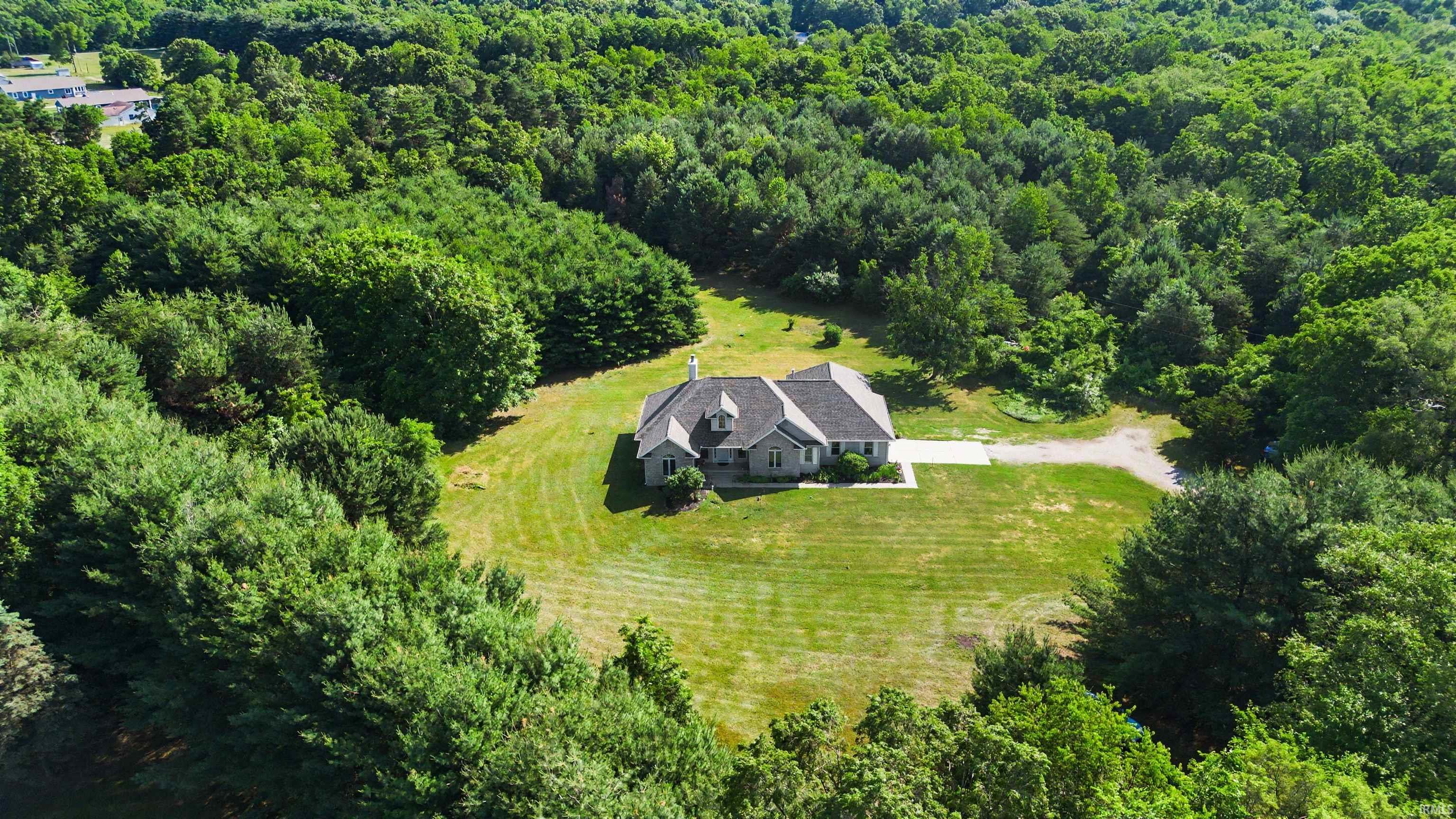 Expansive property featuring a single-story home with a light gray facade and a dark gray roof