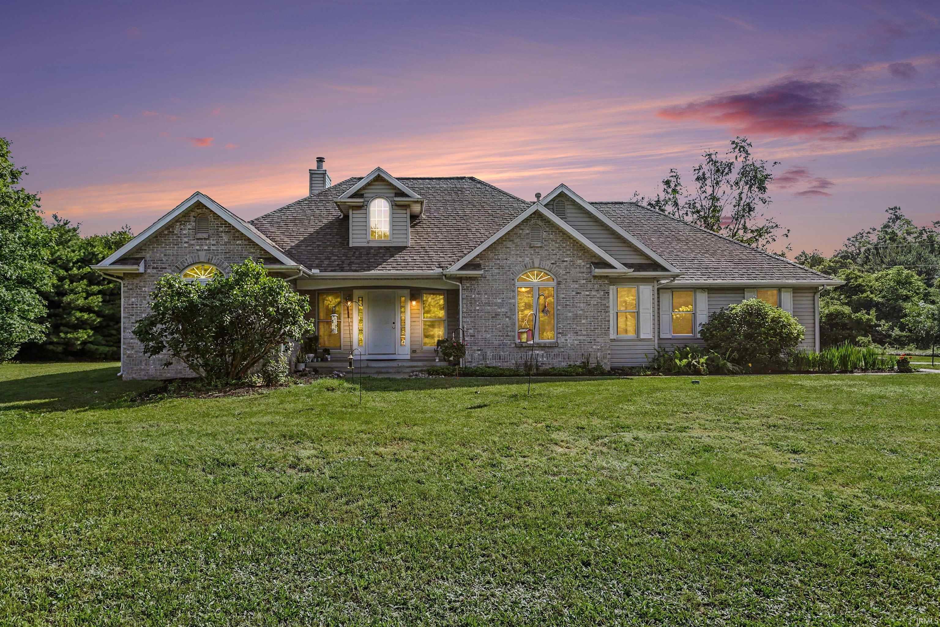 Exterior featuring brick and siding finishes, multiple gables, and an arched transom window above the main entry
