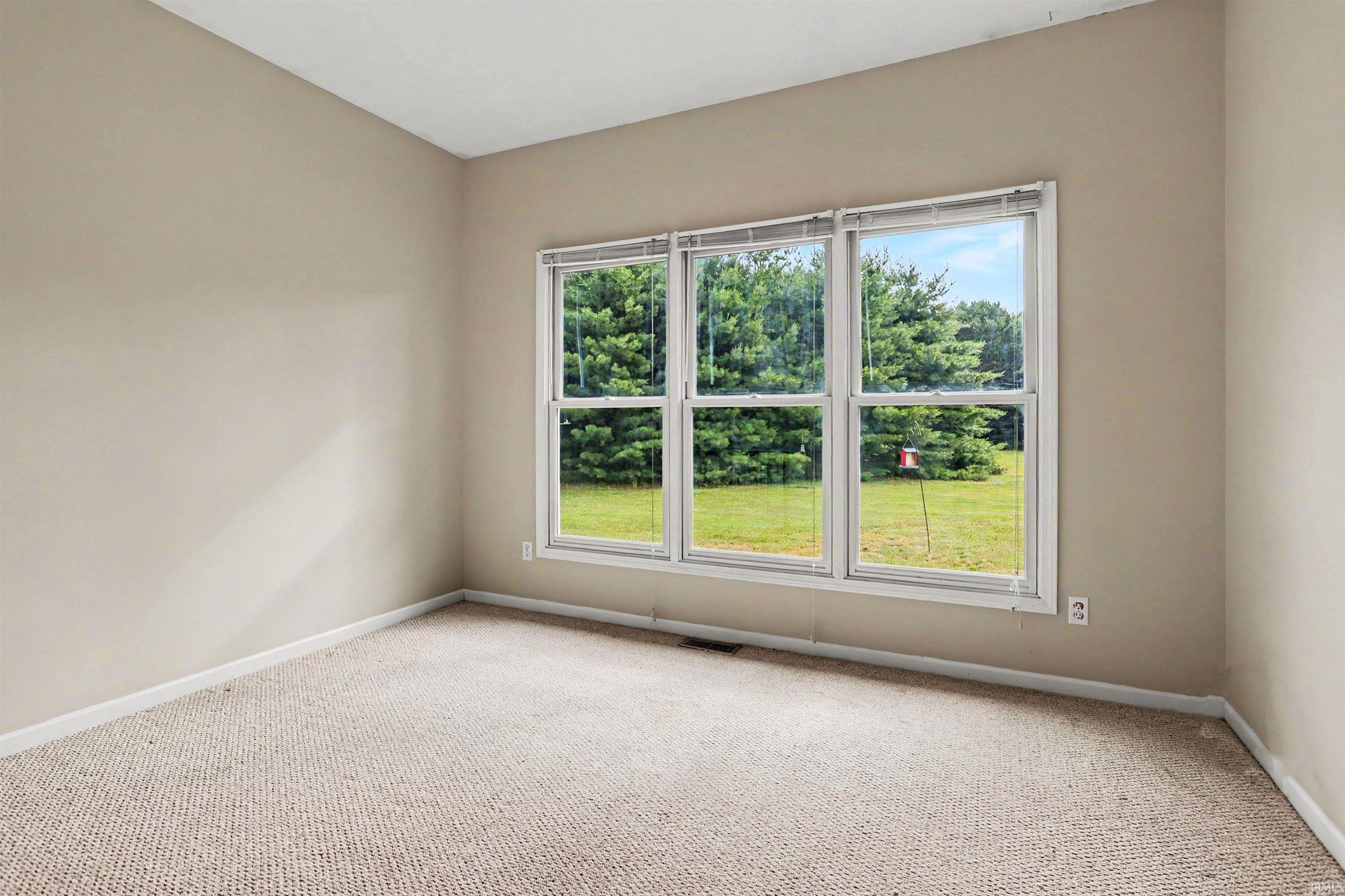 Neutral-toned walls complement the textured carpeting