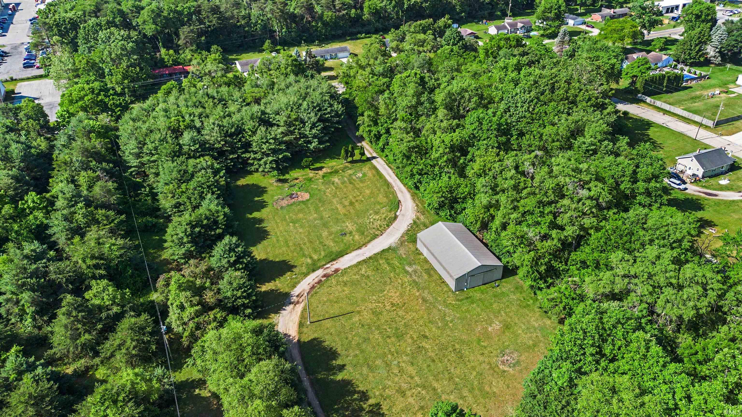 Expansive lot featuring a large metal utility building with a gambrel roof design