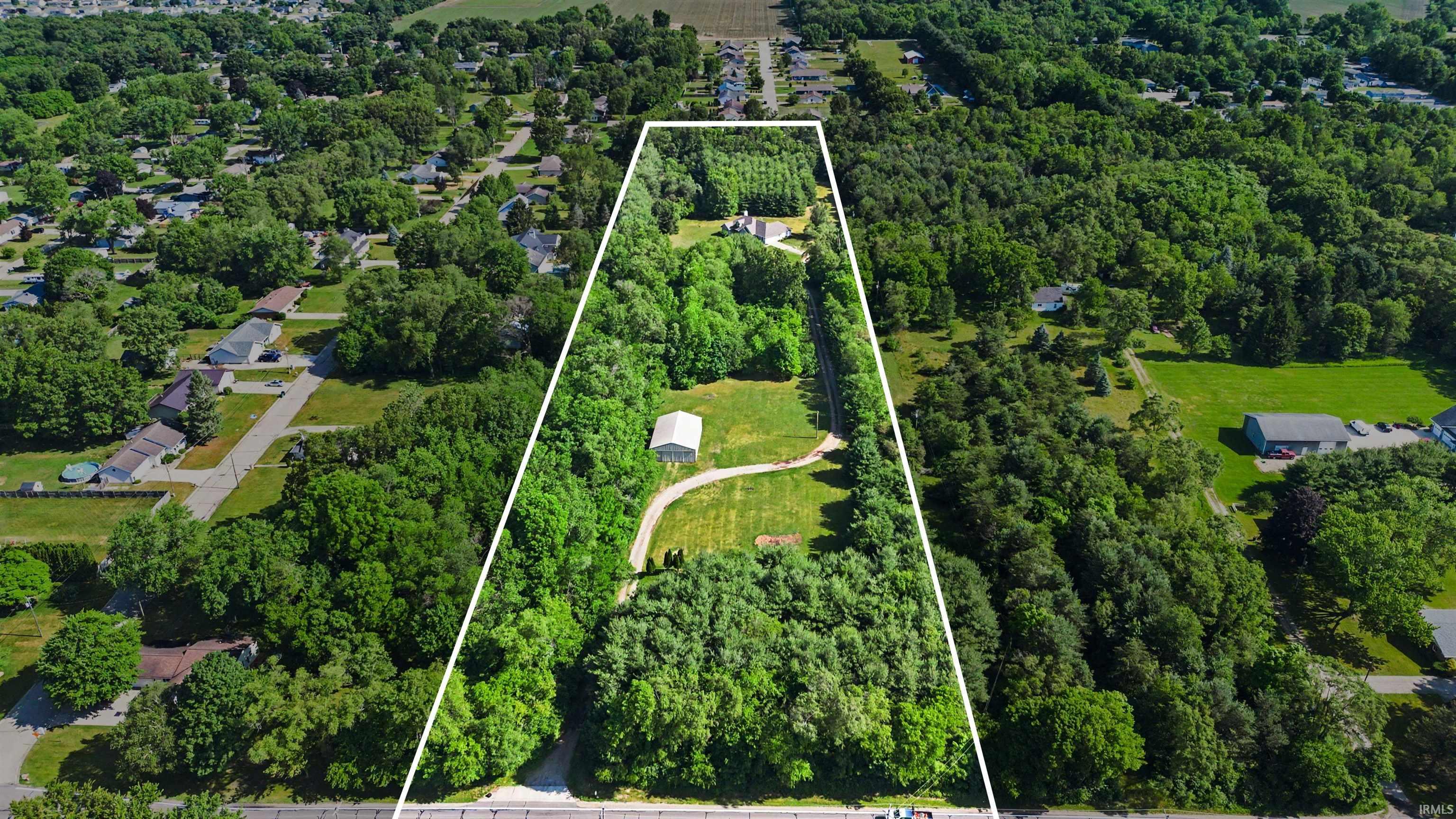 Expansive wooded lot featuring a white outline indicating property boundaries