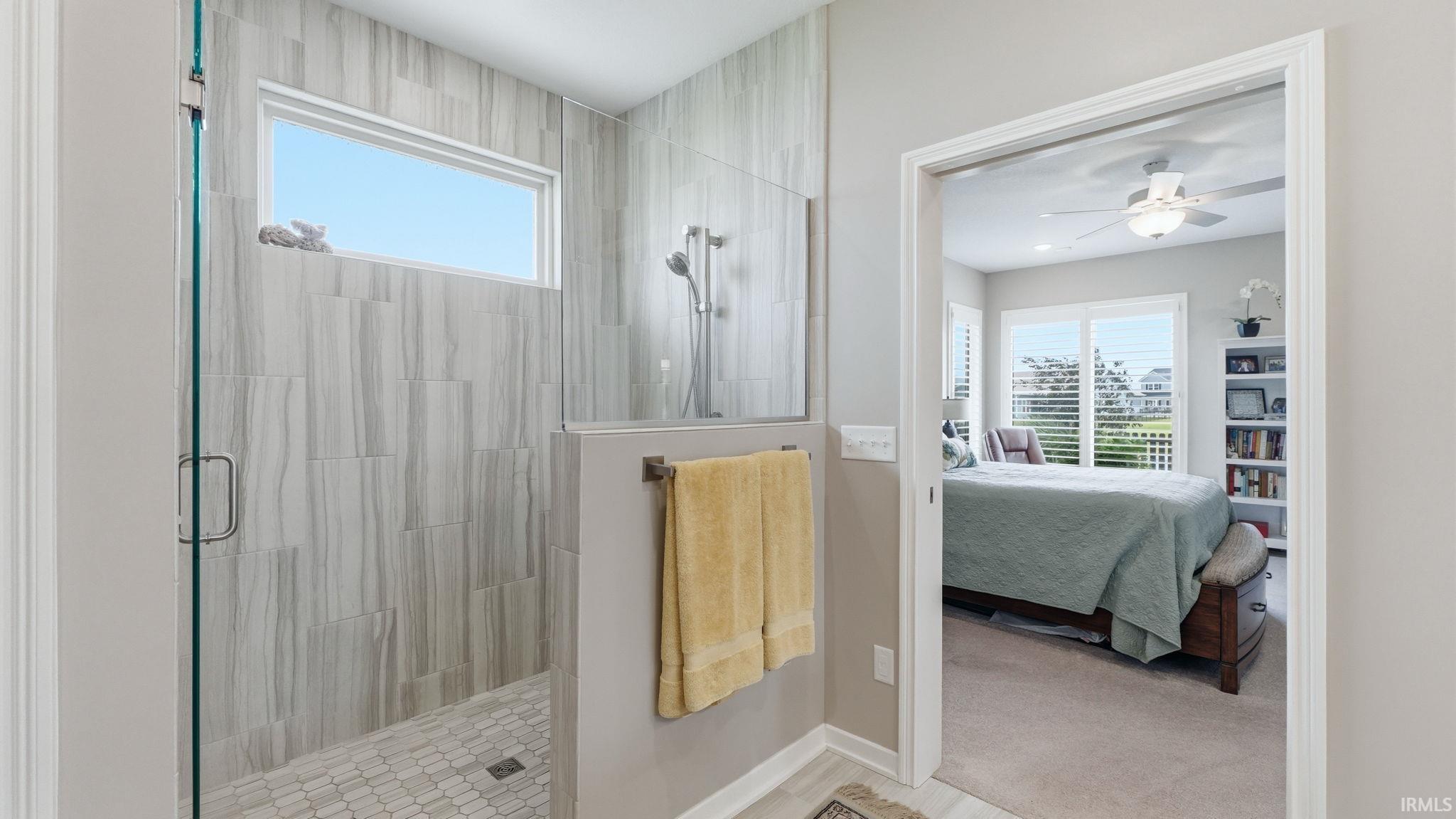 Glass-enclosed shower with wood-finish tile surround and a horizontal window