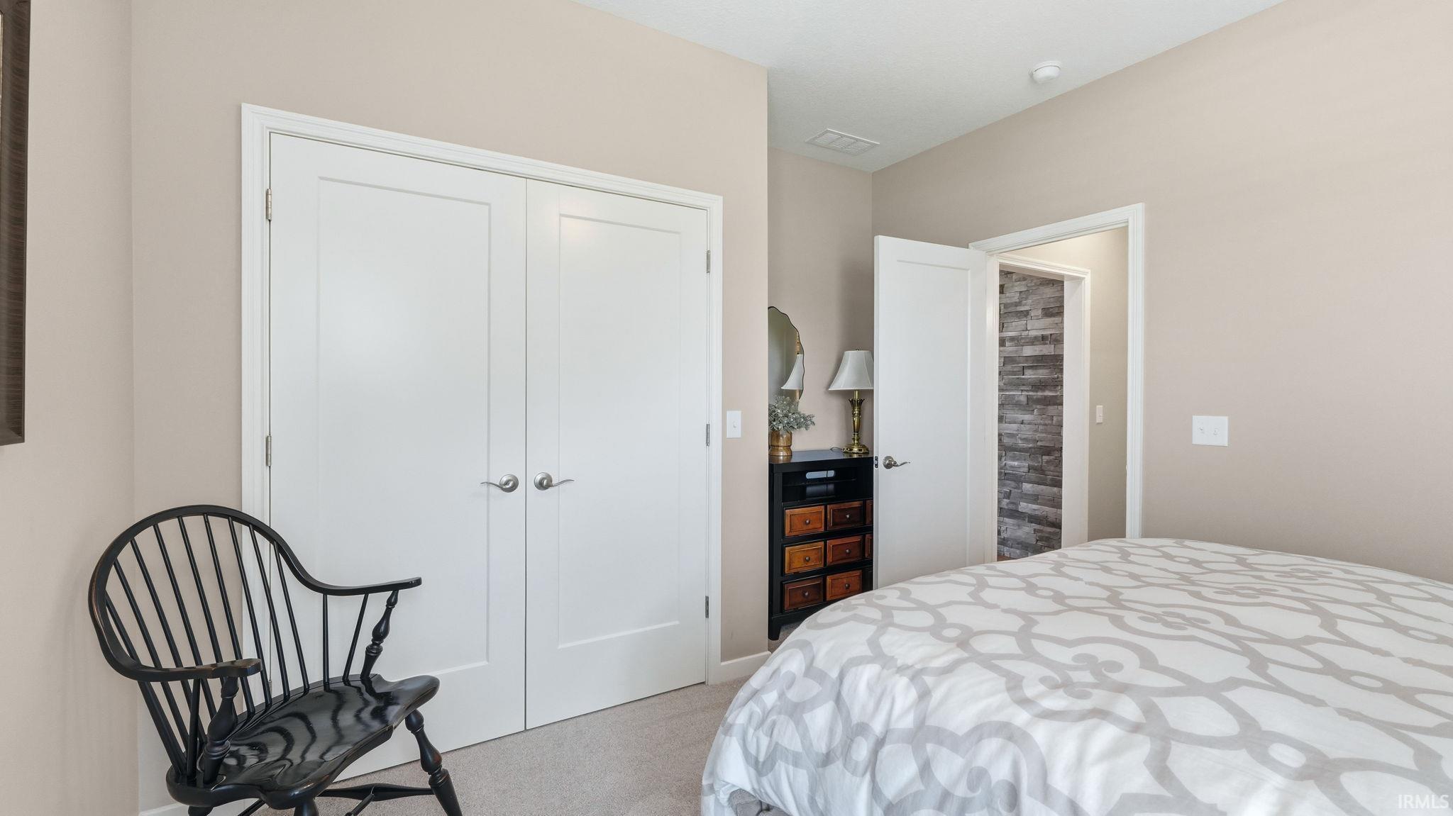 Bedroom featuring light-toned carpeting, neutral wall paint, and white trim