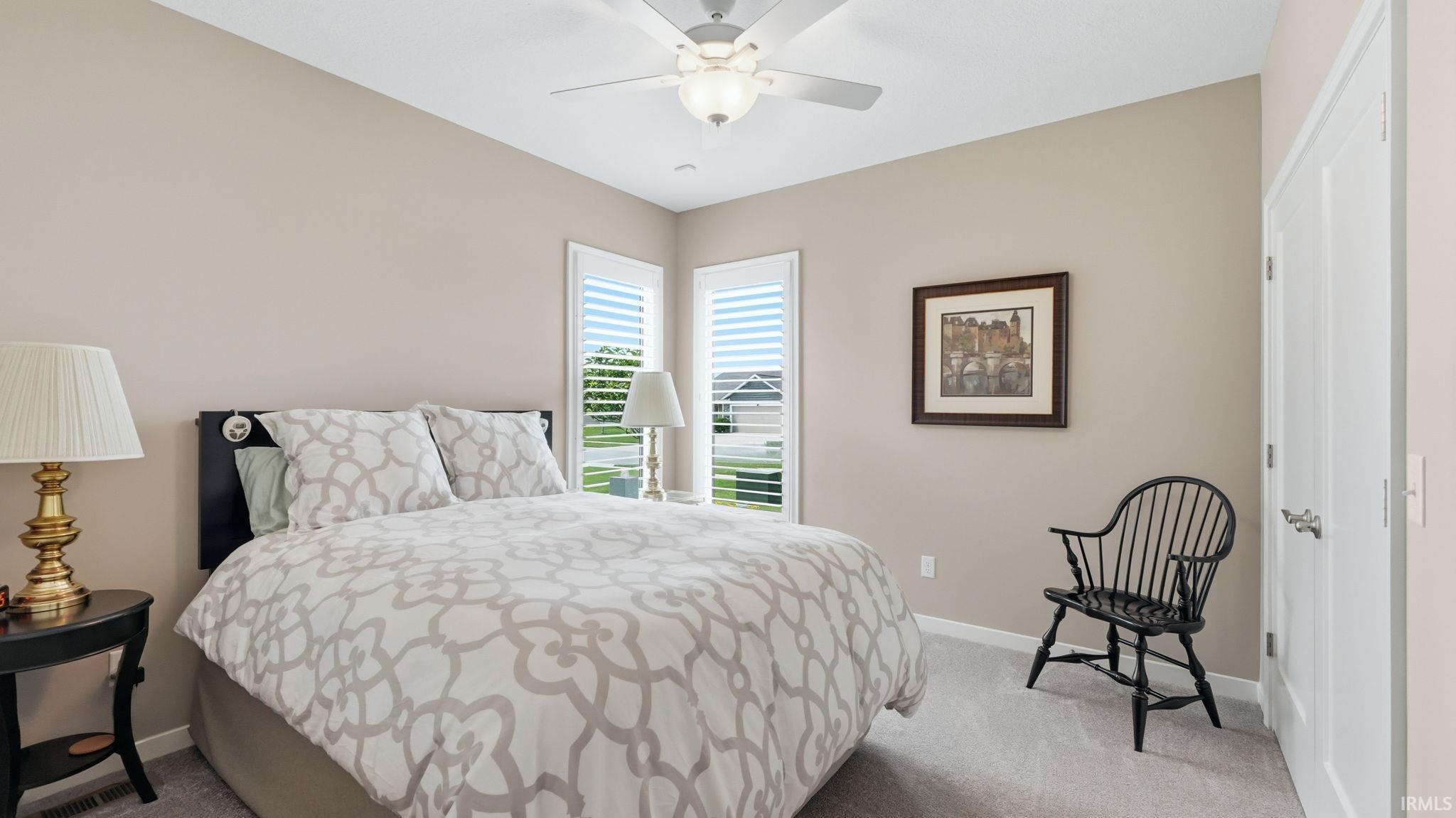 Carpeted bedroom featuring neutral wall tones and a ceiling fan with integrated lighting