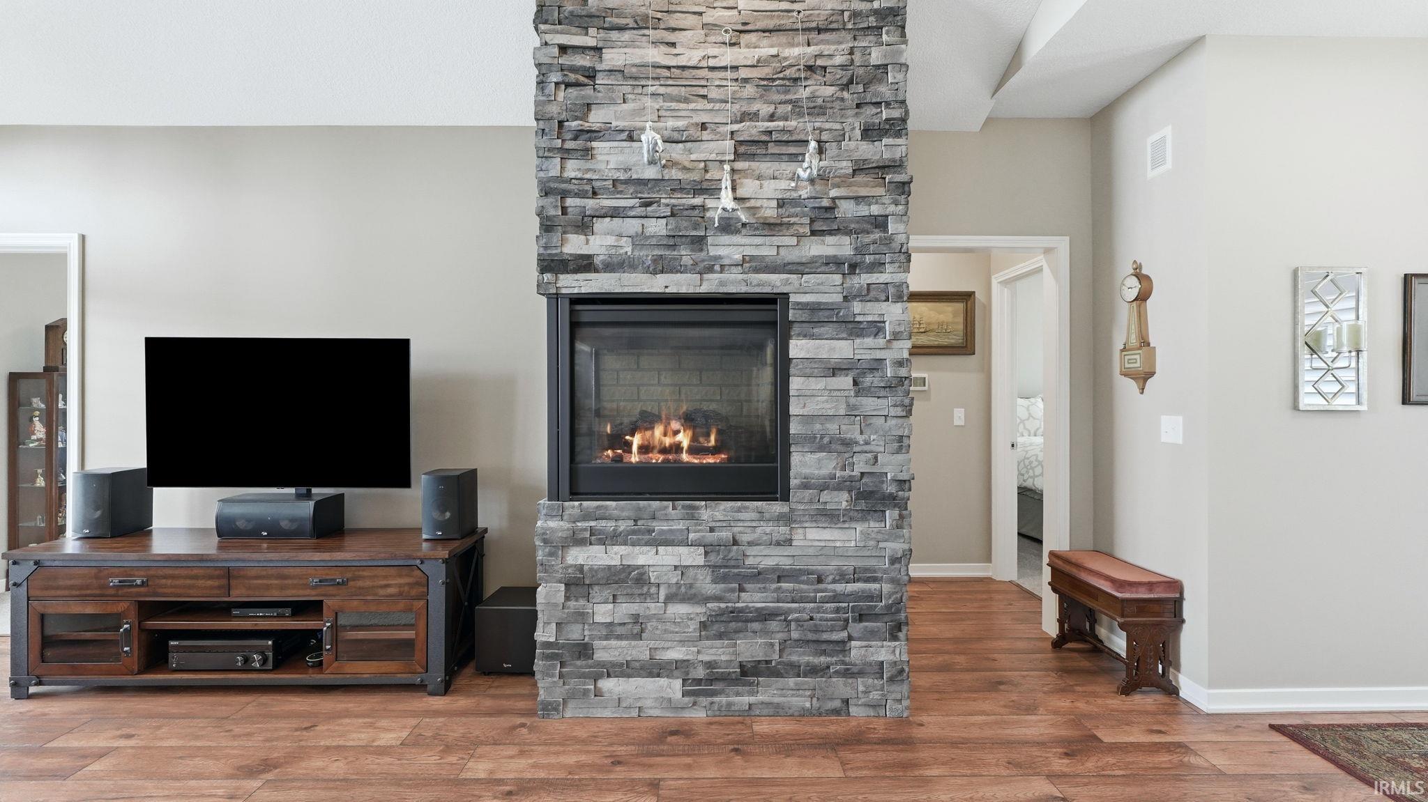 Stacked stone fireplace with a black firebox and integrated lighting