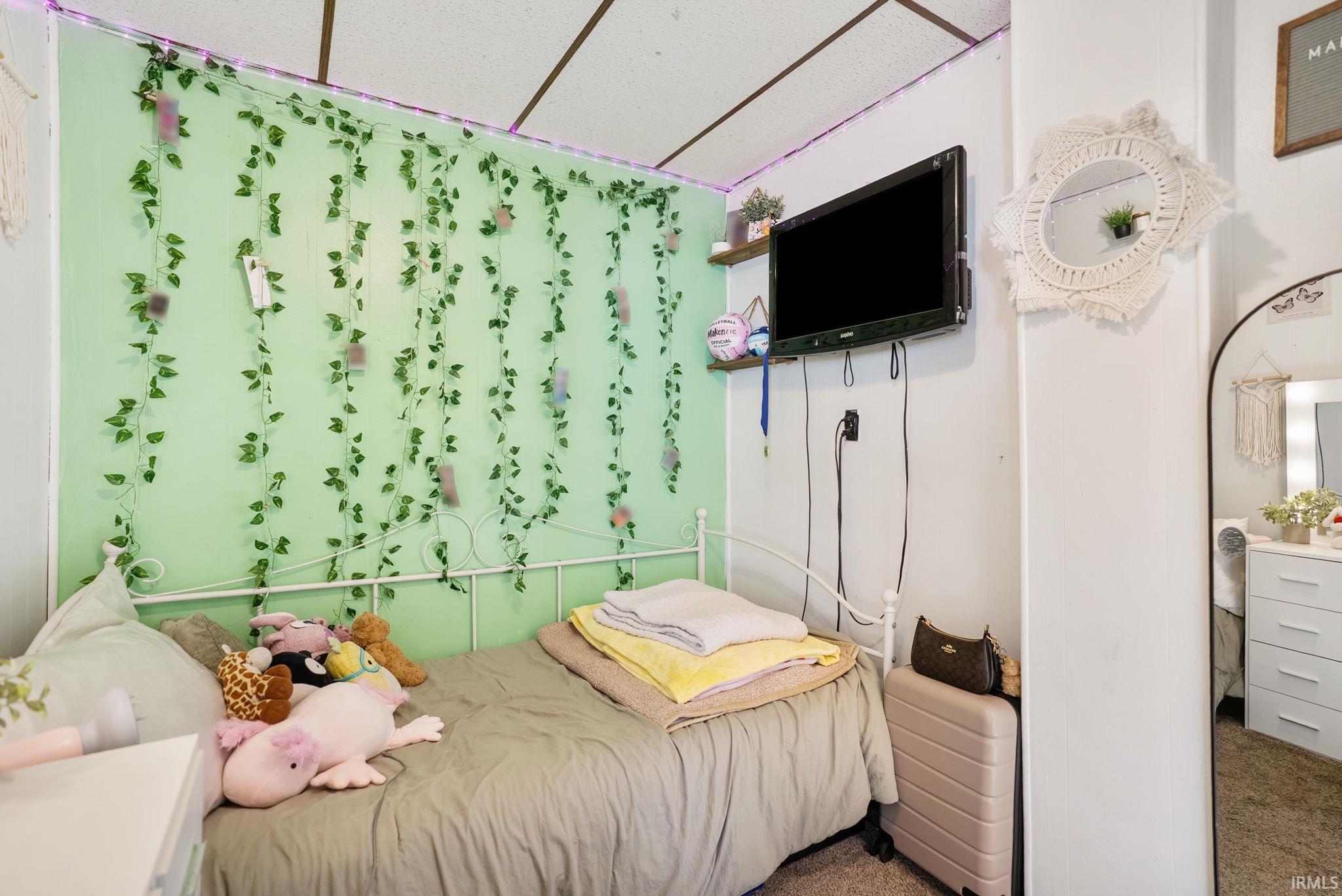 Compact room featuring a single bed with a white metal frame