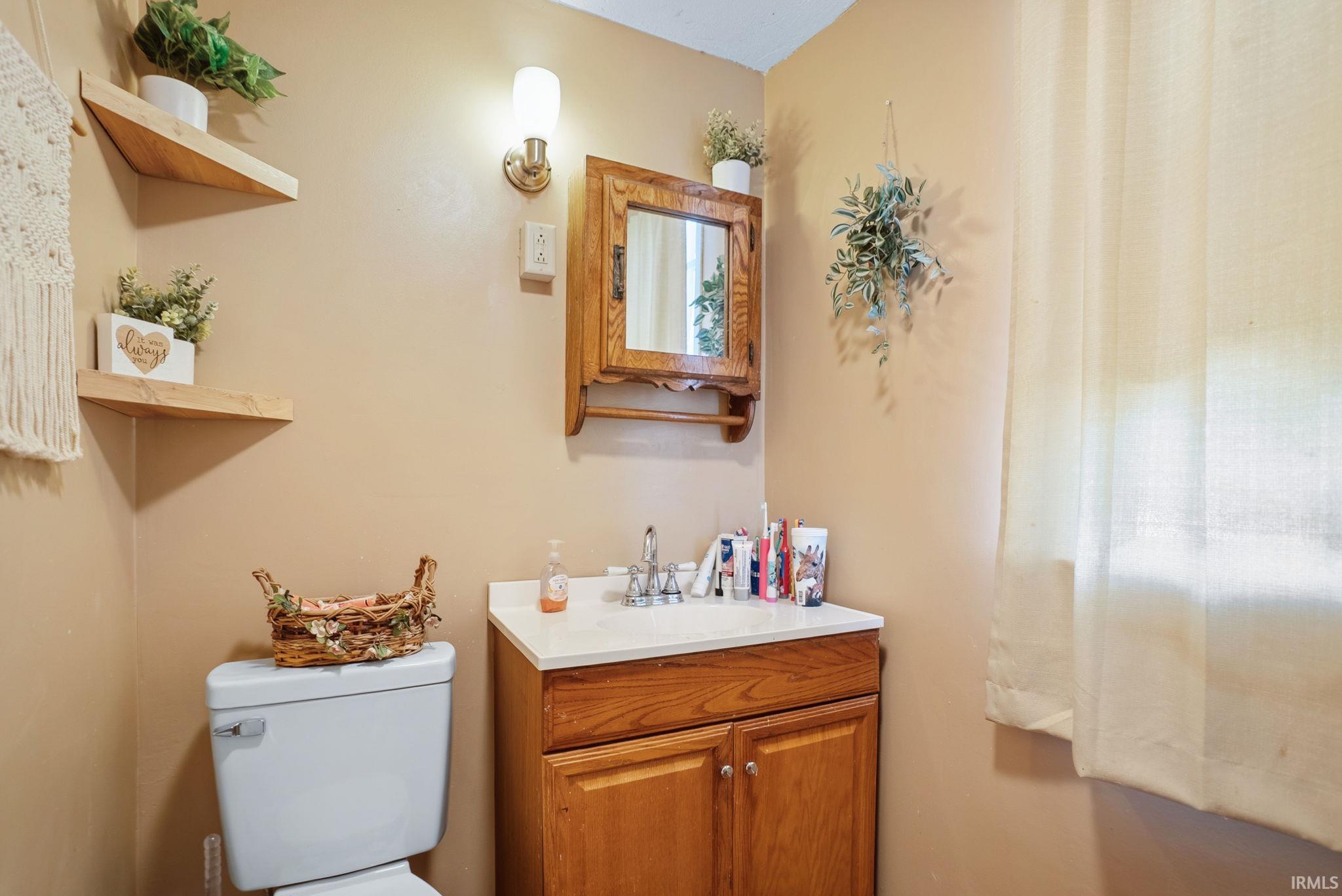 Wood-finish vanity with white countertop and integrated sink, accompanied by a matching wood-finish medicine cabinet