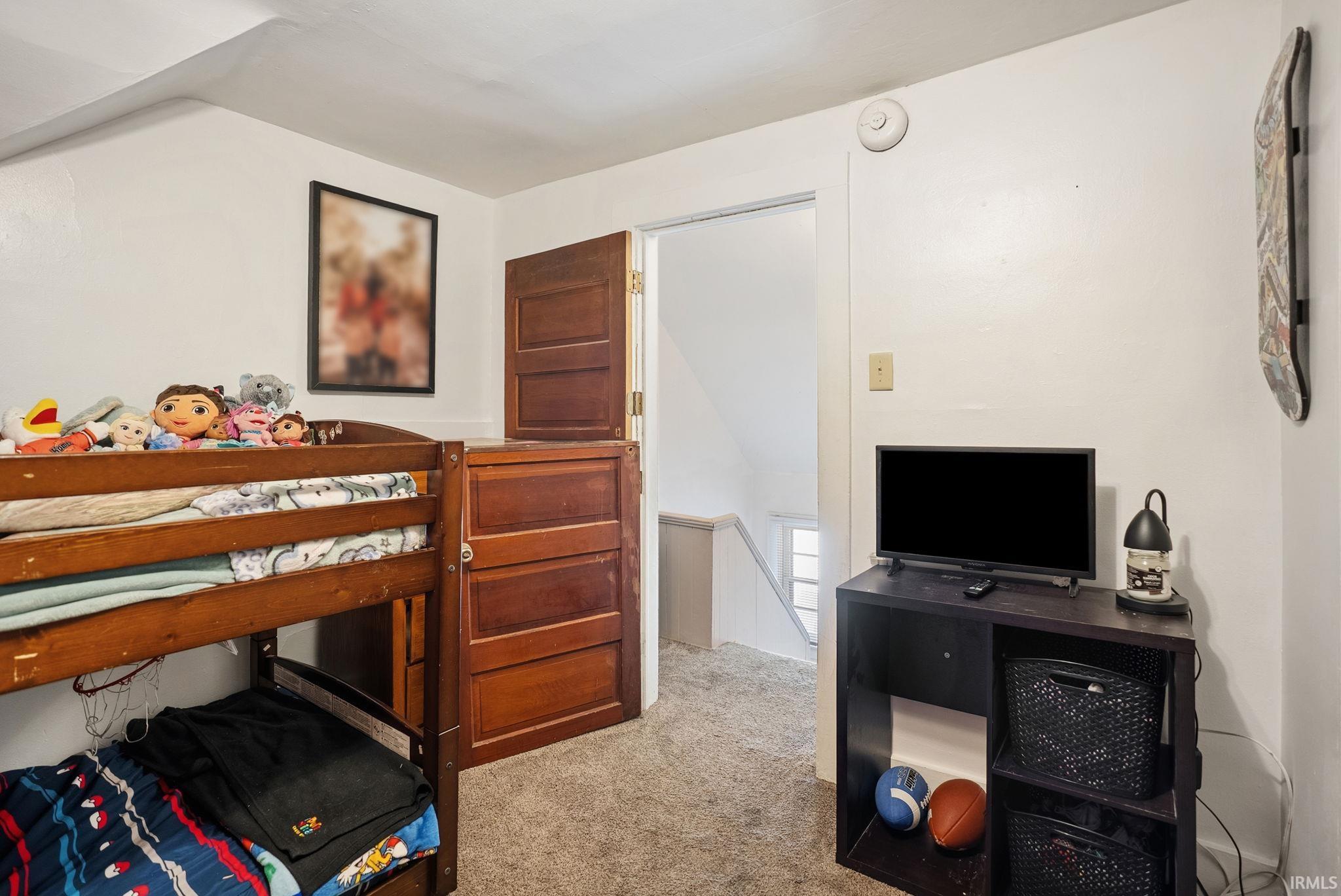Carpeted room with a half-door entry and sloped ceilings