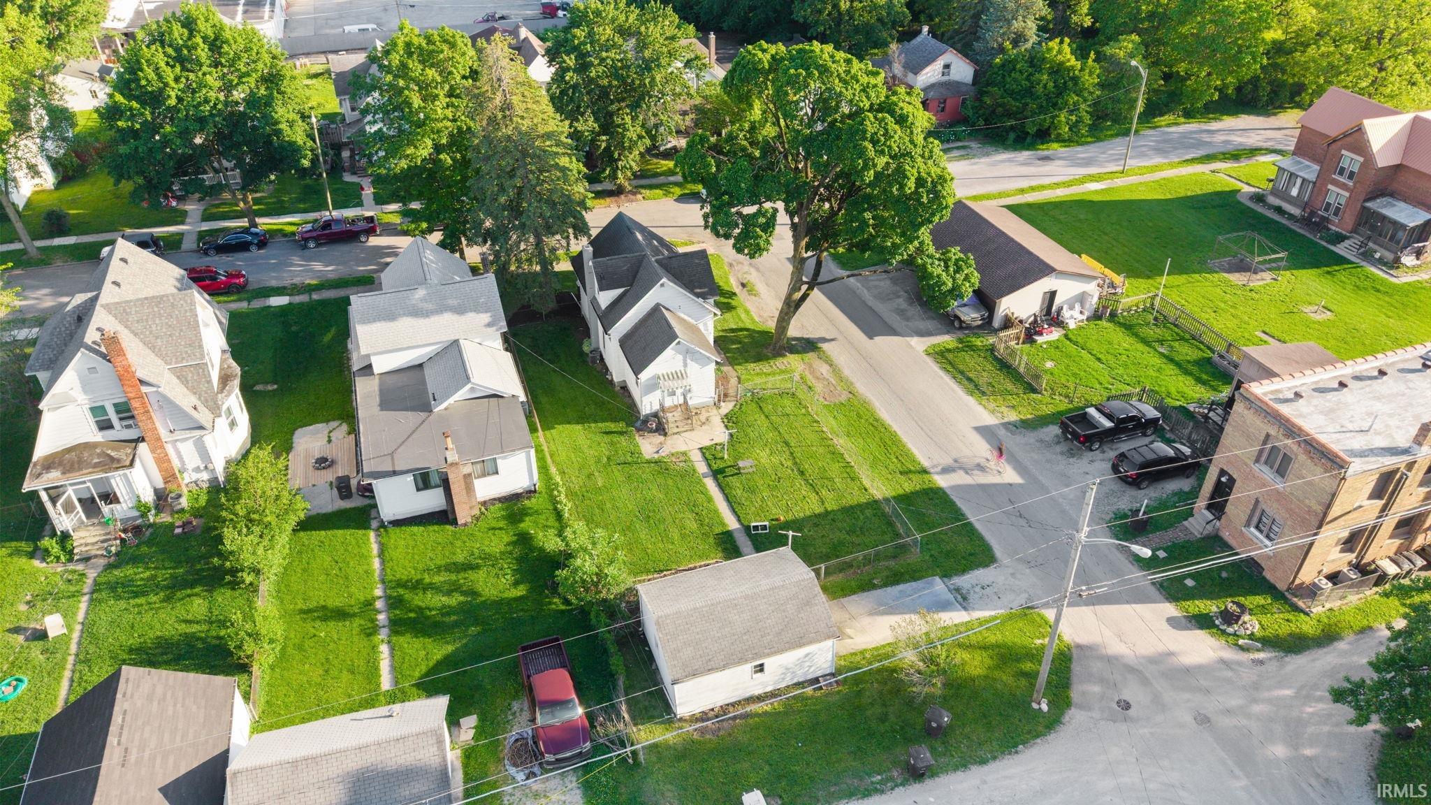Aerial perspective of a neighborhood featuring multiple residential structures and verdant landscaping