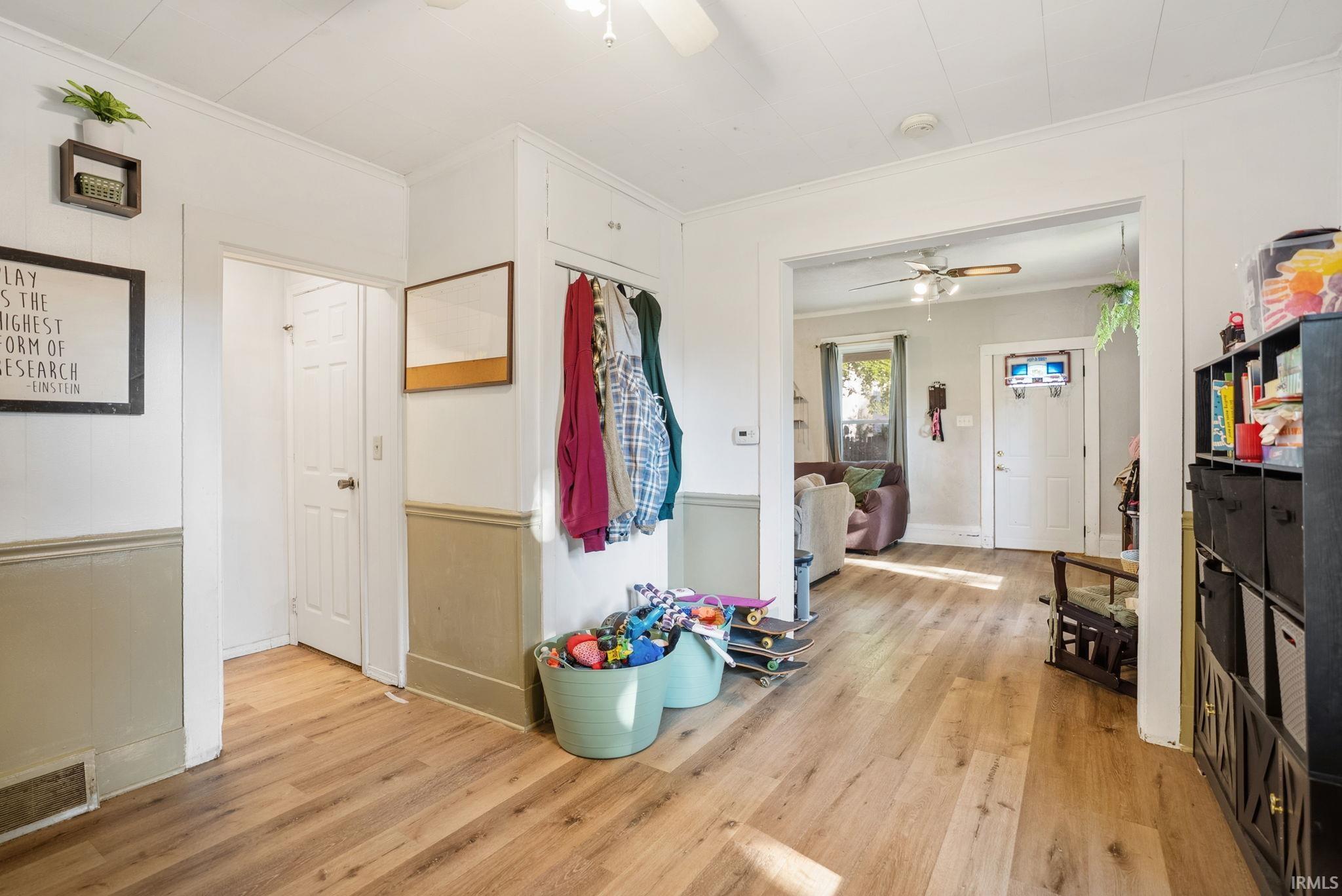 Entry area featuring wood-finish flooring, white paneled ceilings, and neutral two-tone wall finishes
