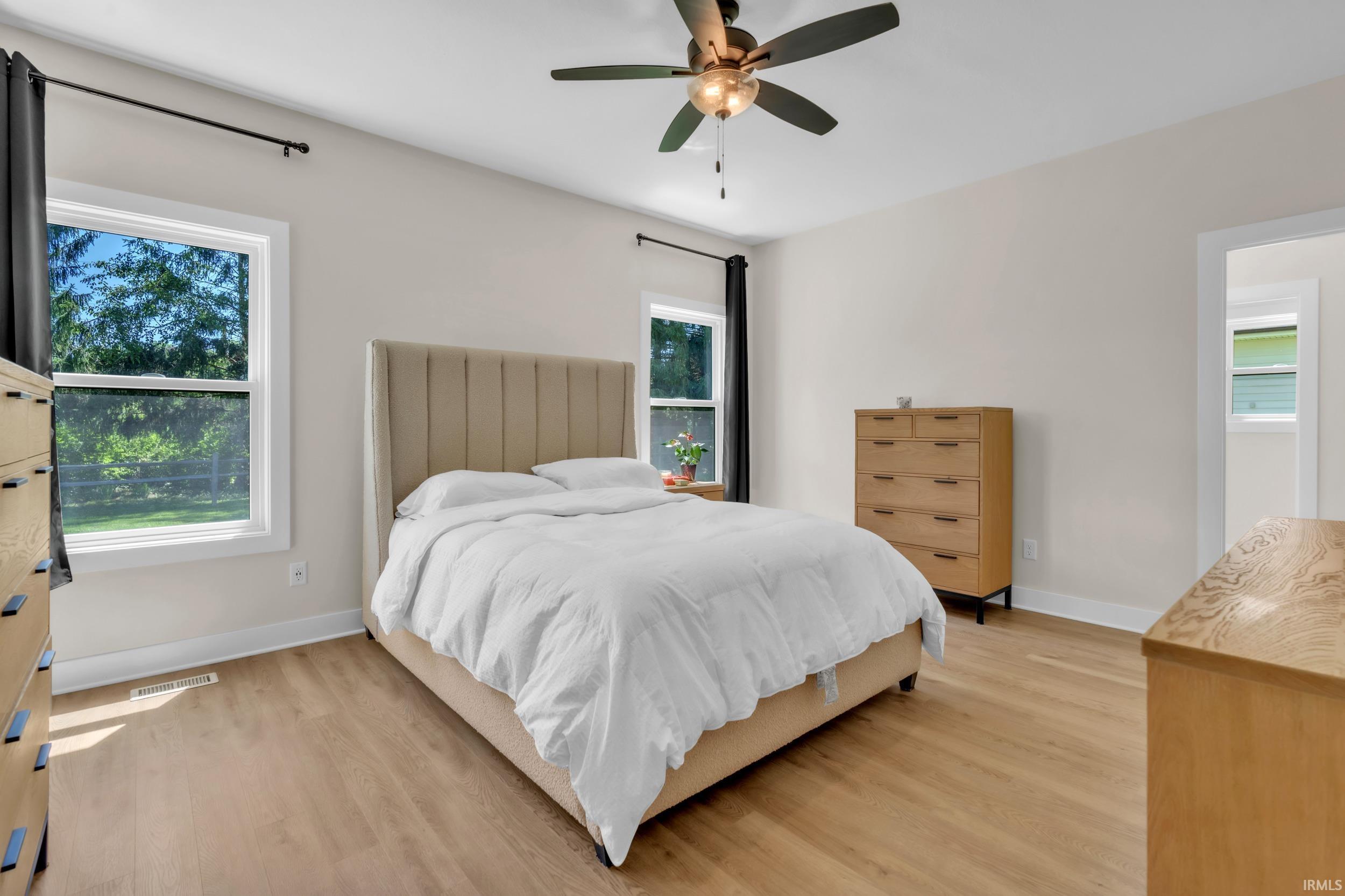 Bright room featuring wood-finish flooring, white trim, and light-colored walls