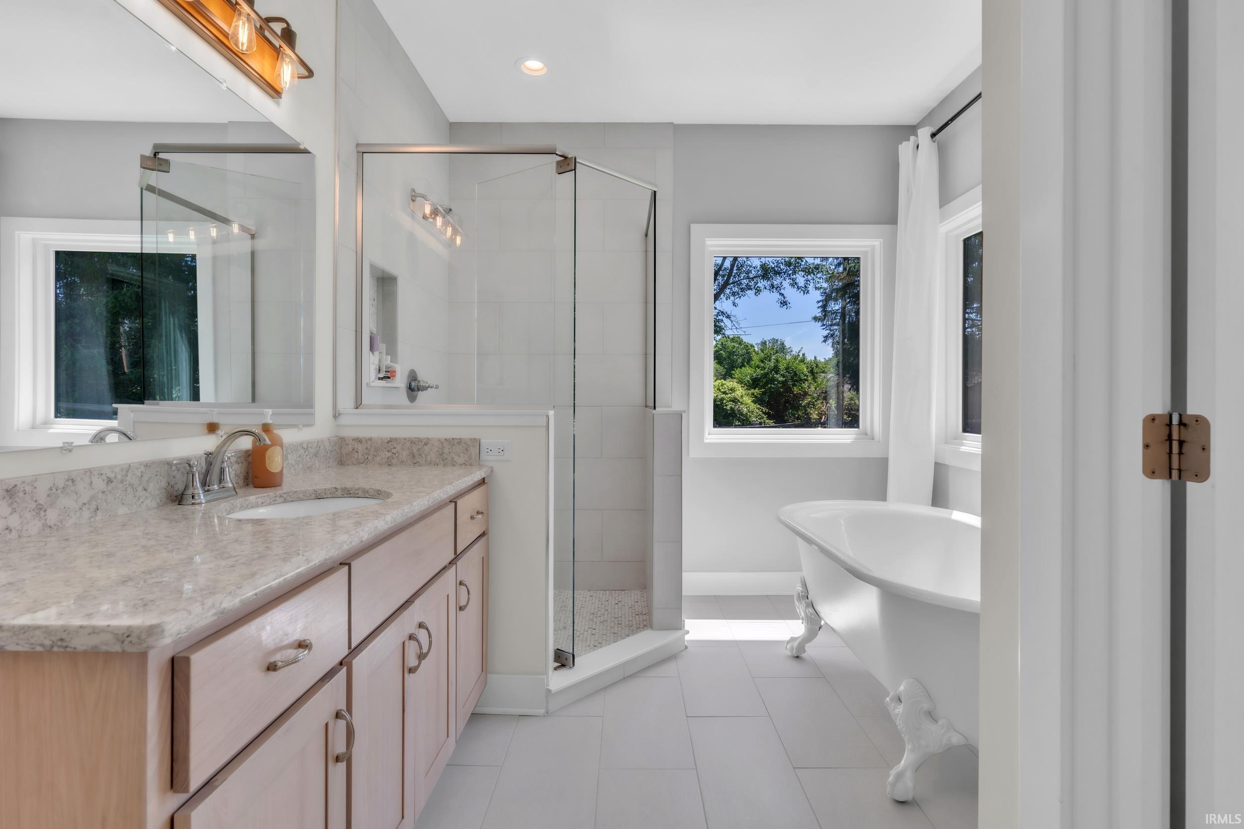 Bathroom featuring a double vanity with light-toned cabinetry and a stone-finish countertop