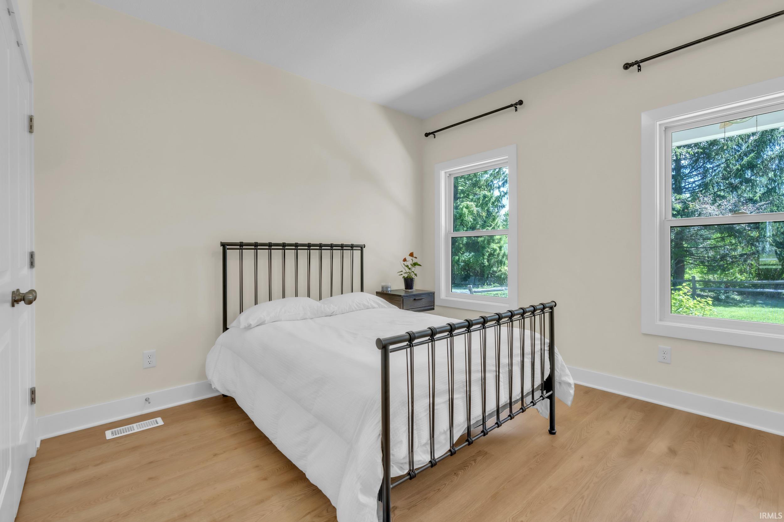 Spacious room featuring light wood-finish flooring, neutral wall tones, and bright white trim