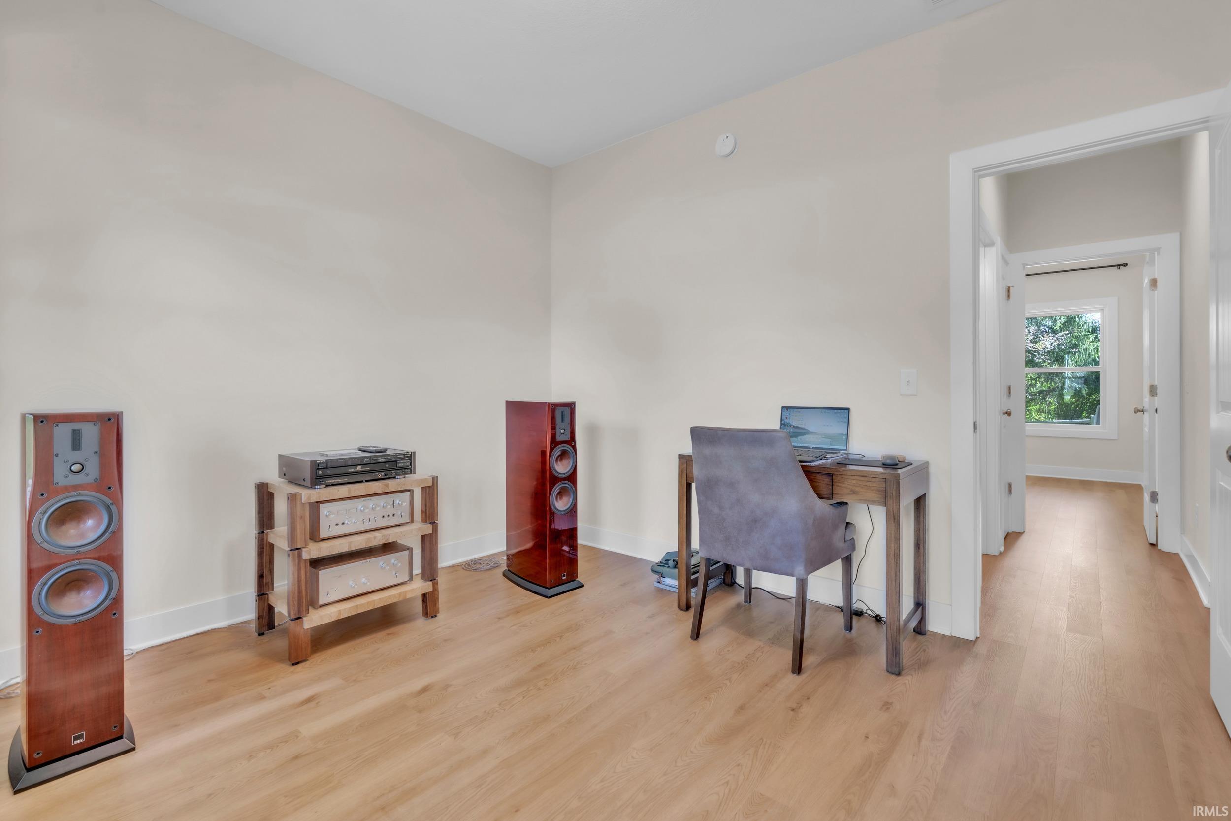Light-toned wood-finish flooring throughout, bright white baseboards, and neutral wall paint