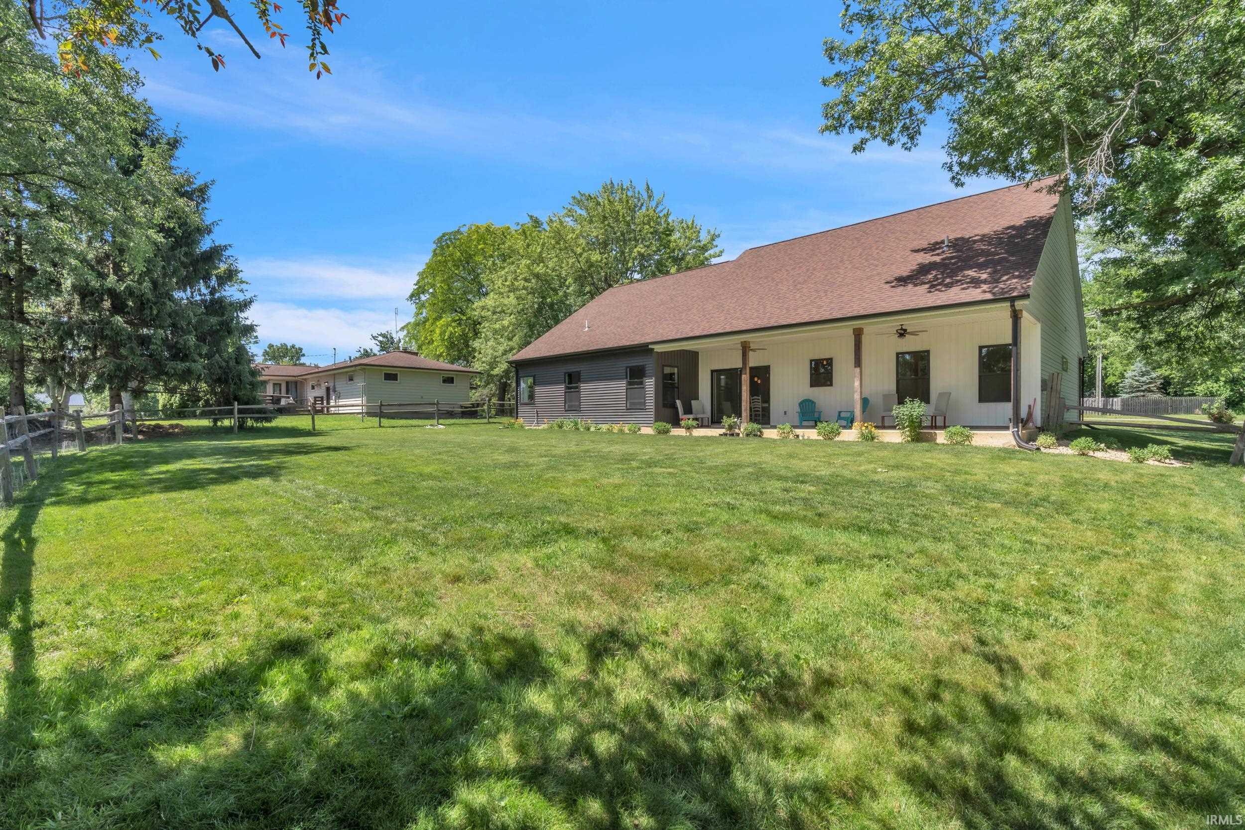 Expansive green lawn bordering a modern farmhouse-style residence