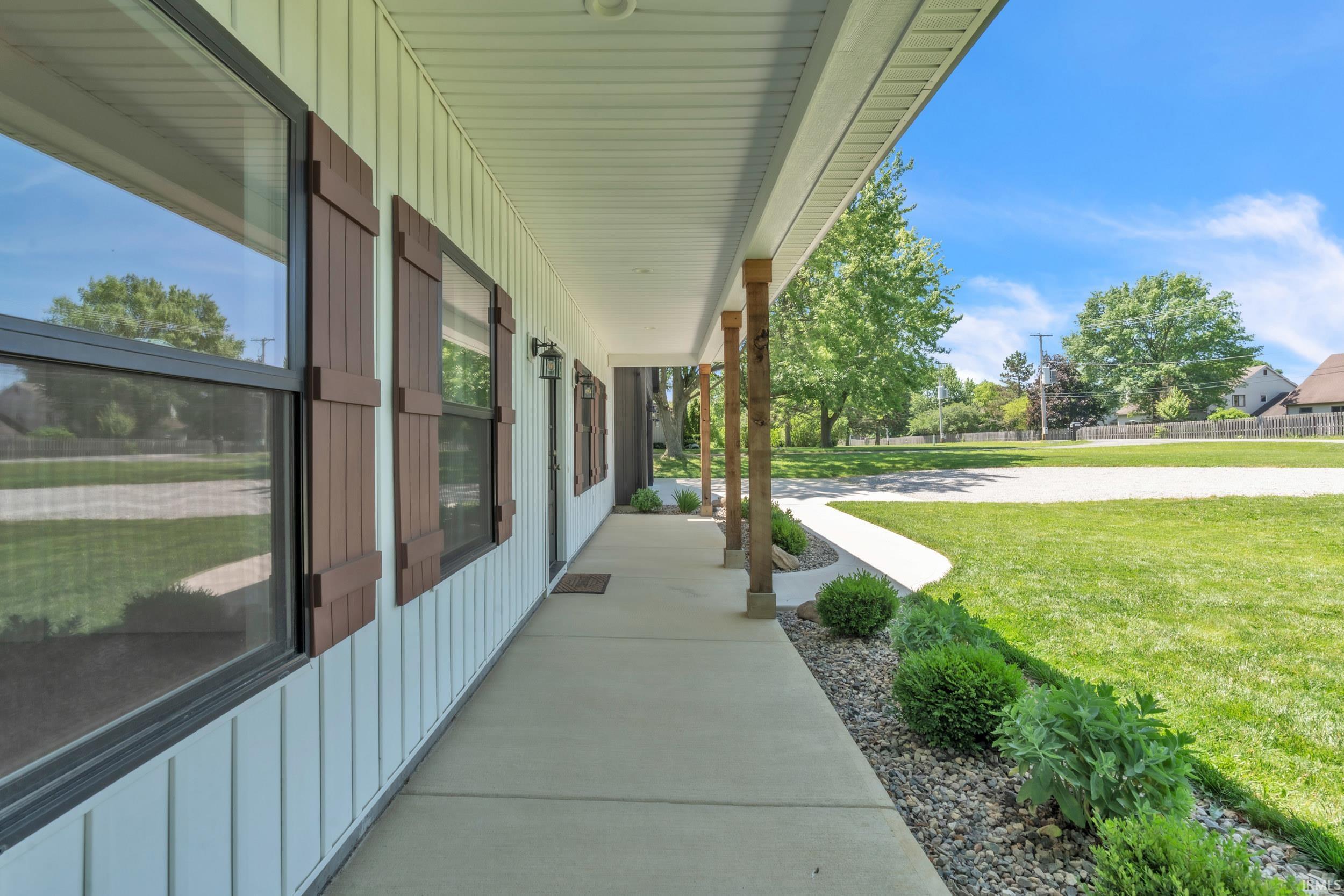 Inviting covered front porch with exposed wood posts and a concrete walkway