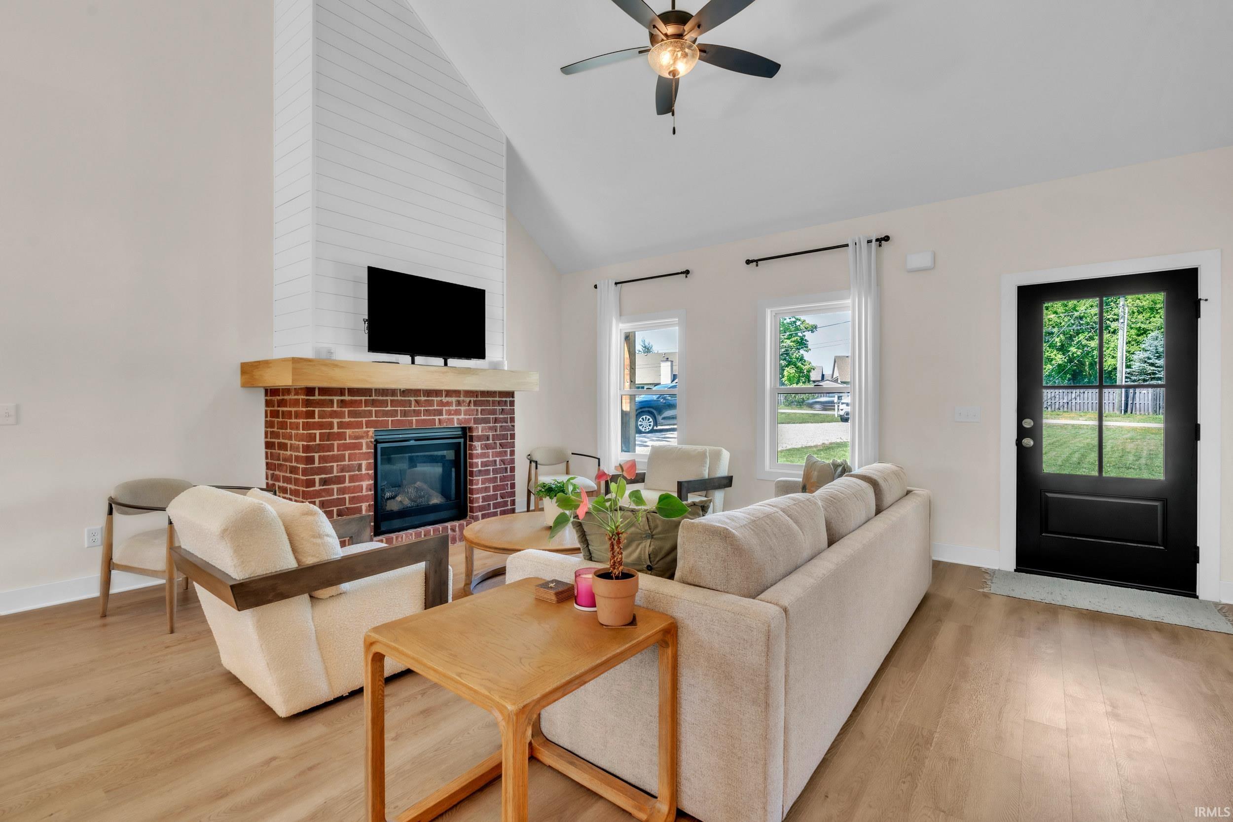 Living area featuring a vaulted ceiling and wood-finish flooring