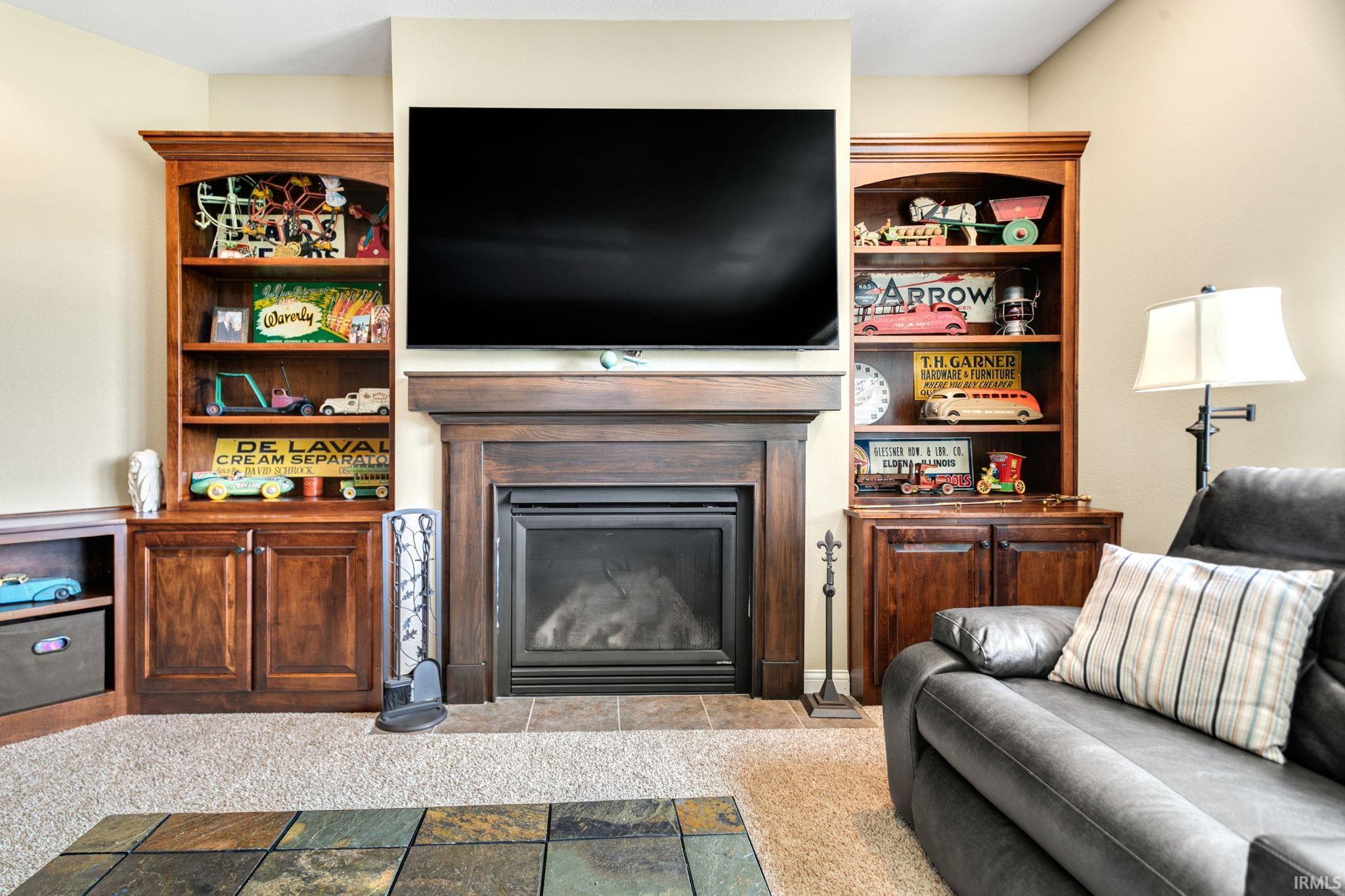 Central fireplace featuring a dark wood mantel and tile hearth