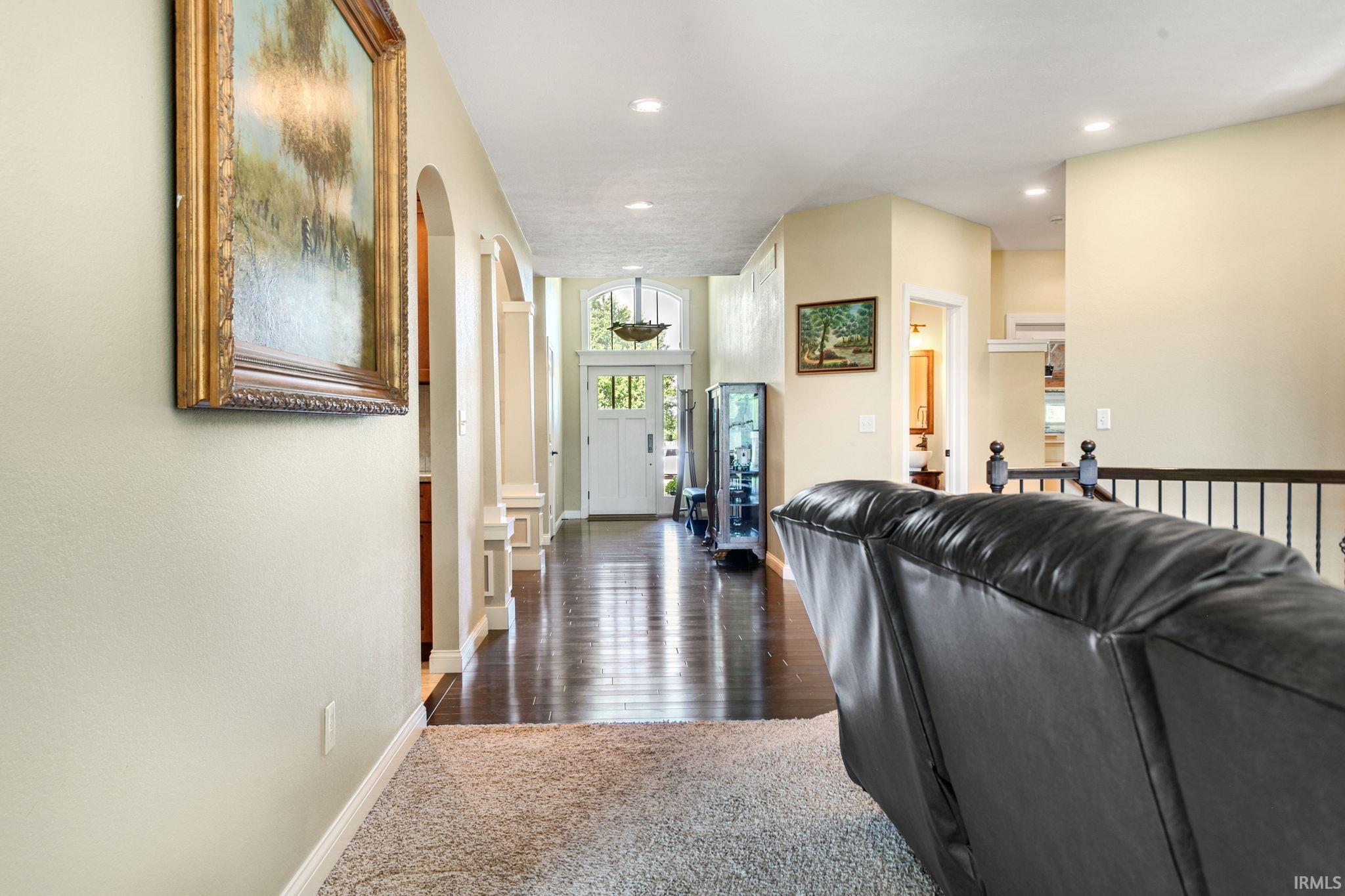 Entryway featuring dark wood-finish flooring, recessed lighting, and a white paneled front door with sidelights and transom window