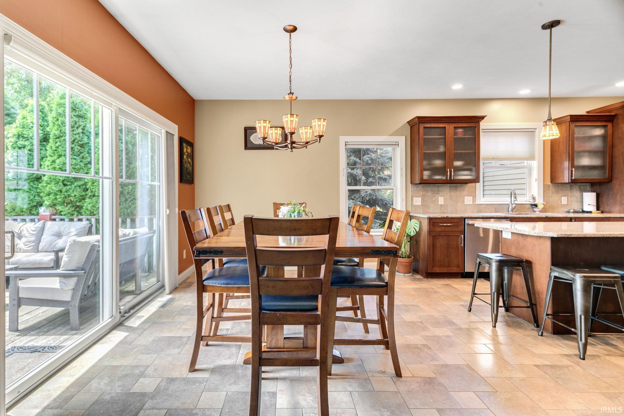 Dining area featuring large sliding glass doors, a chandelier, and tile flooring