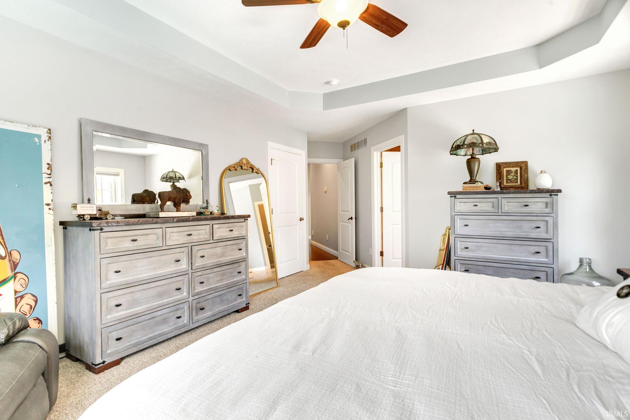 Spacious interior featuring a tray ceiling, recessed lighting, and a ceiling fan