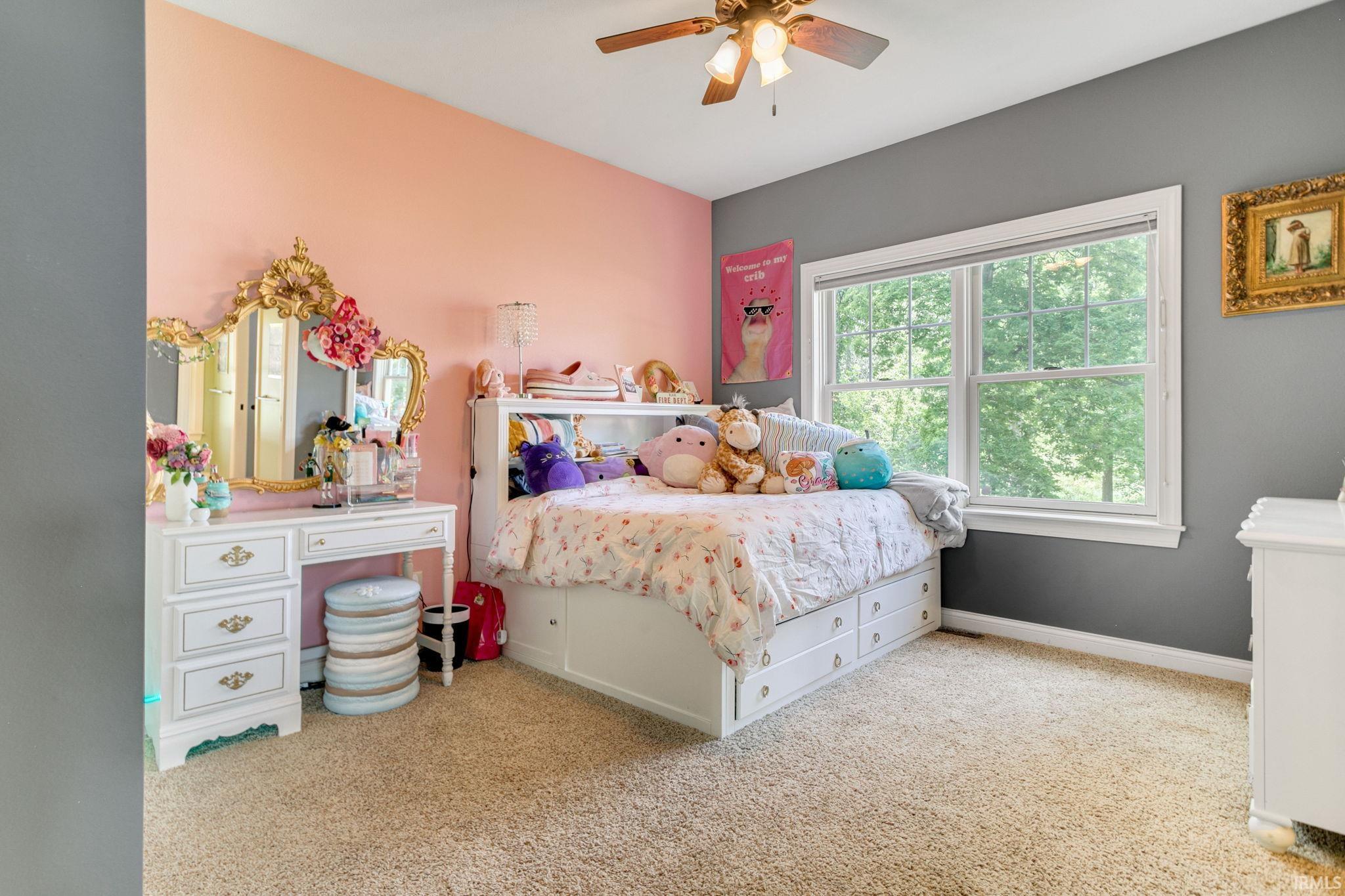Carpeted interior space featuring a double window, ceiling fan with light fixture, and white trim