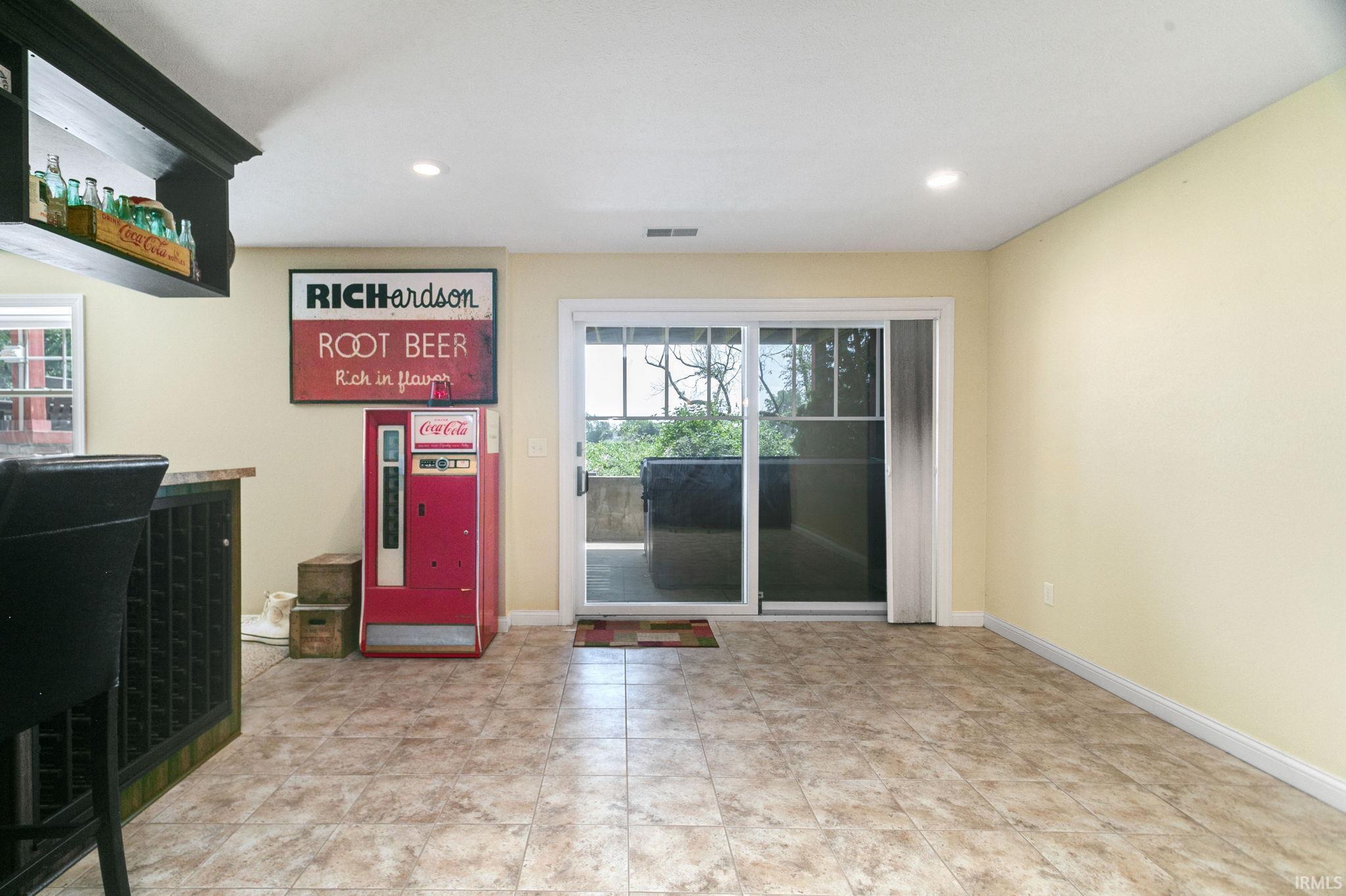 Spacious room featuring tile flooring, light-toned walls, and recessed lighting
