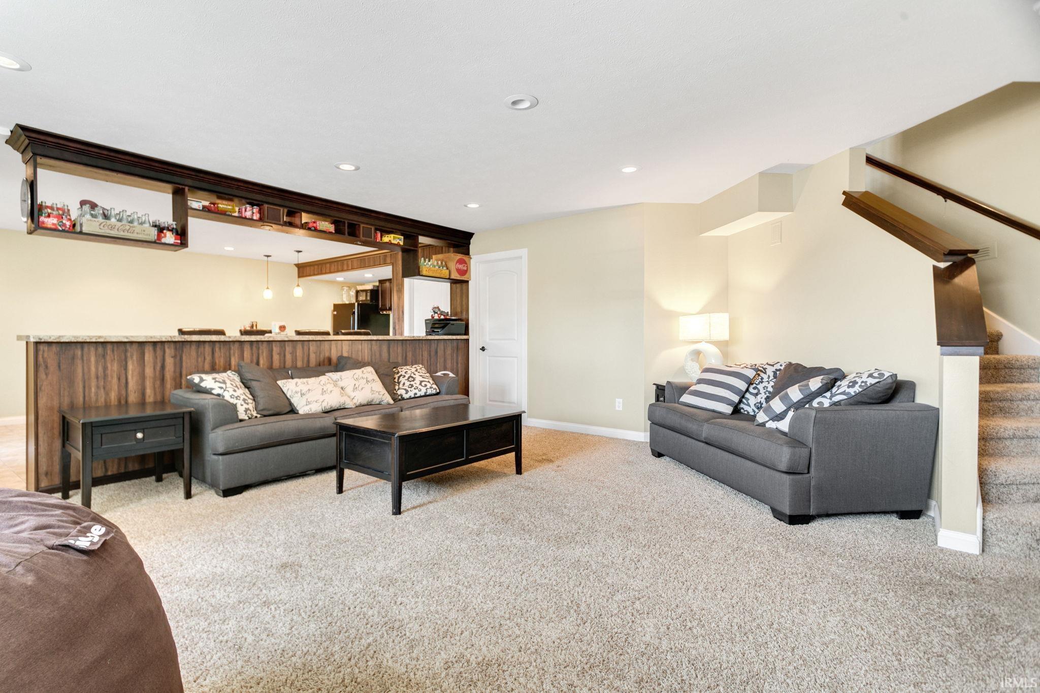 Lower level recreation space featuring a wood-panel accent wall and built-in shelving