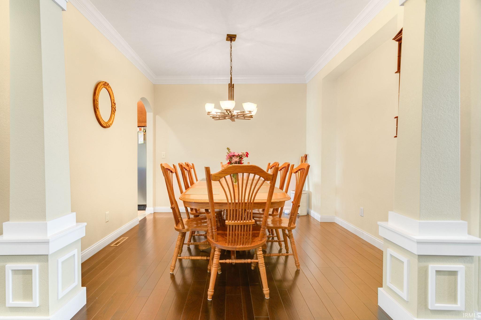 Formal dining space featuring dark wood-finish flooring and an ornate chandelier