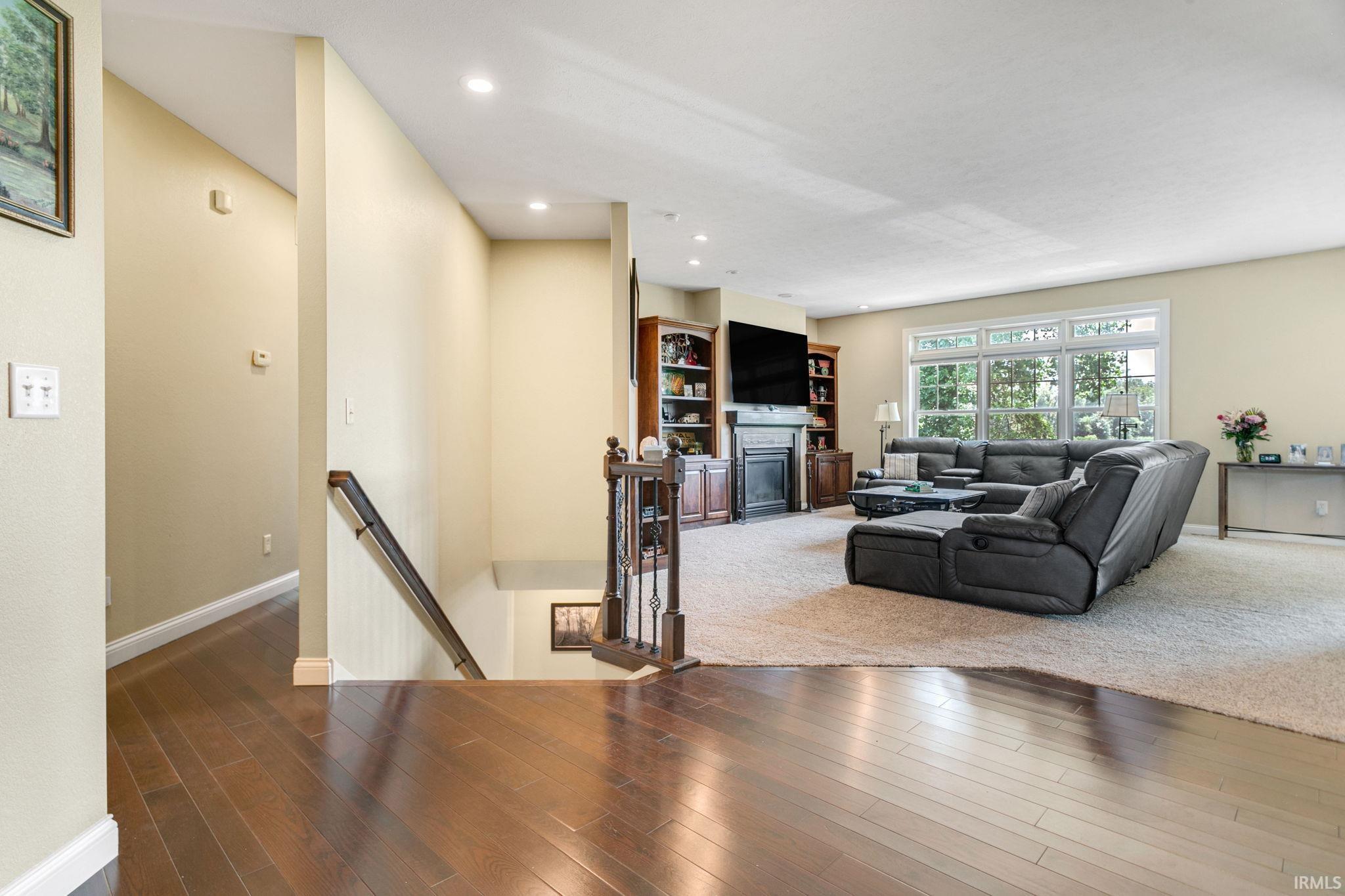 Spacious living area featuring expansive windows, recessed lighting, and a fireplace with built-in cabinetry