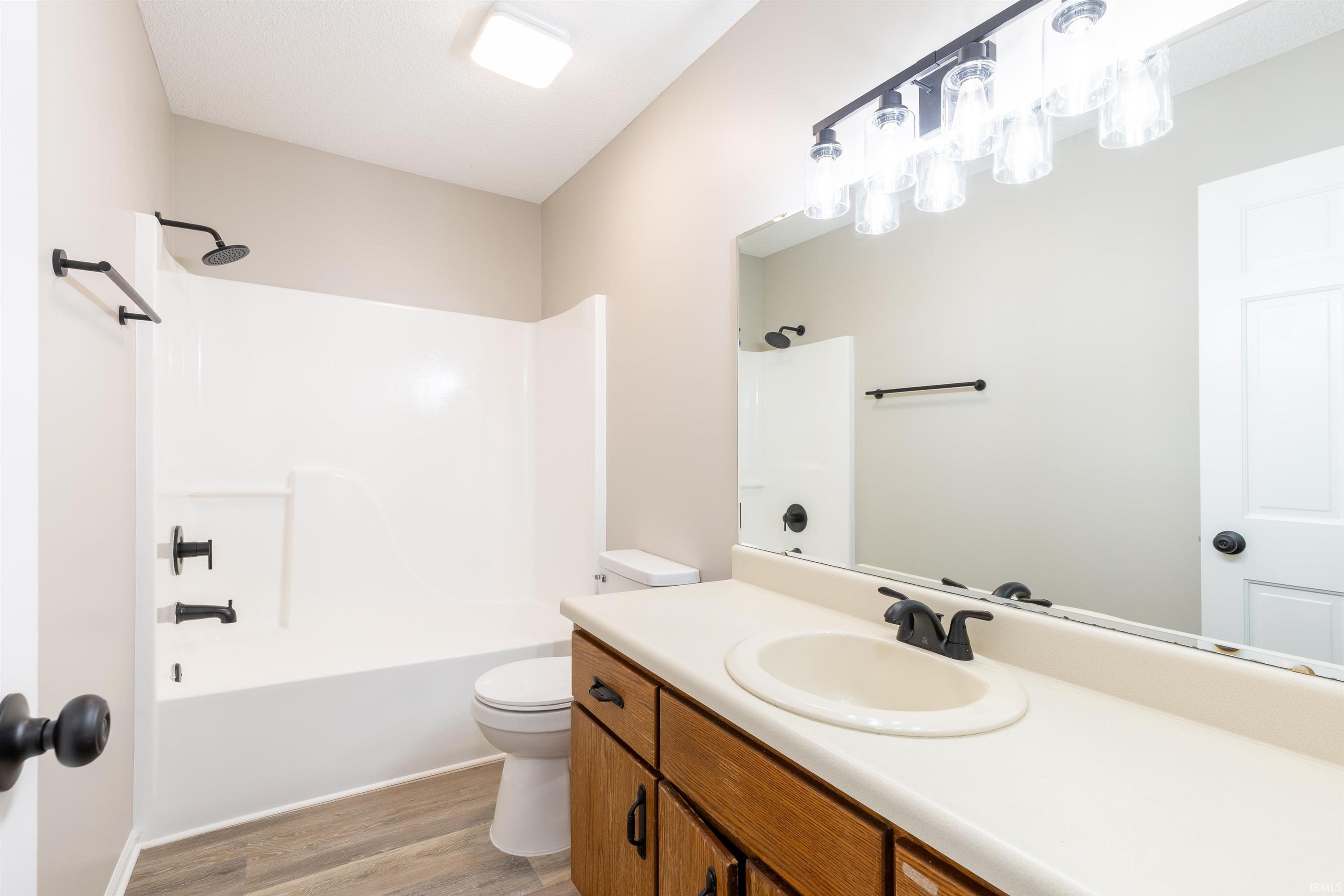 Bathroom featuring a single vanity with wood-finish cabinetry and a light-colored countertop
