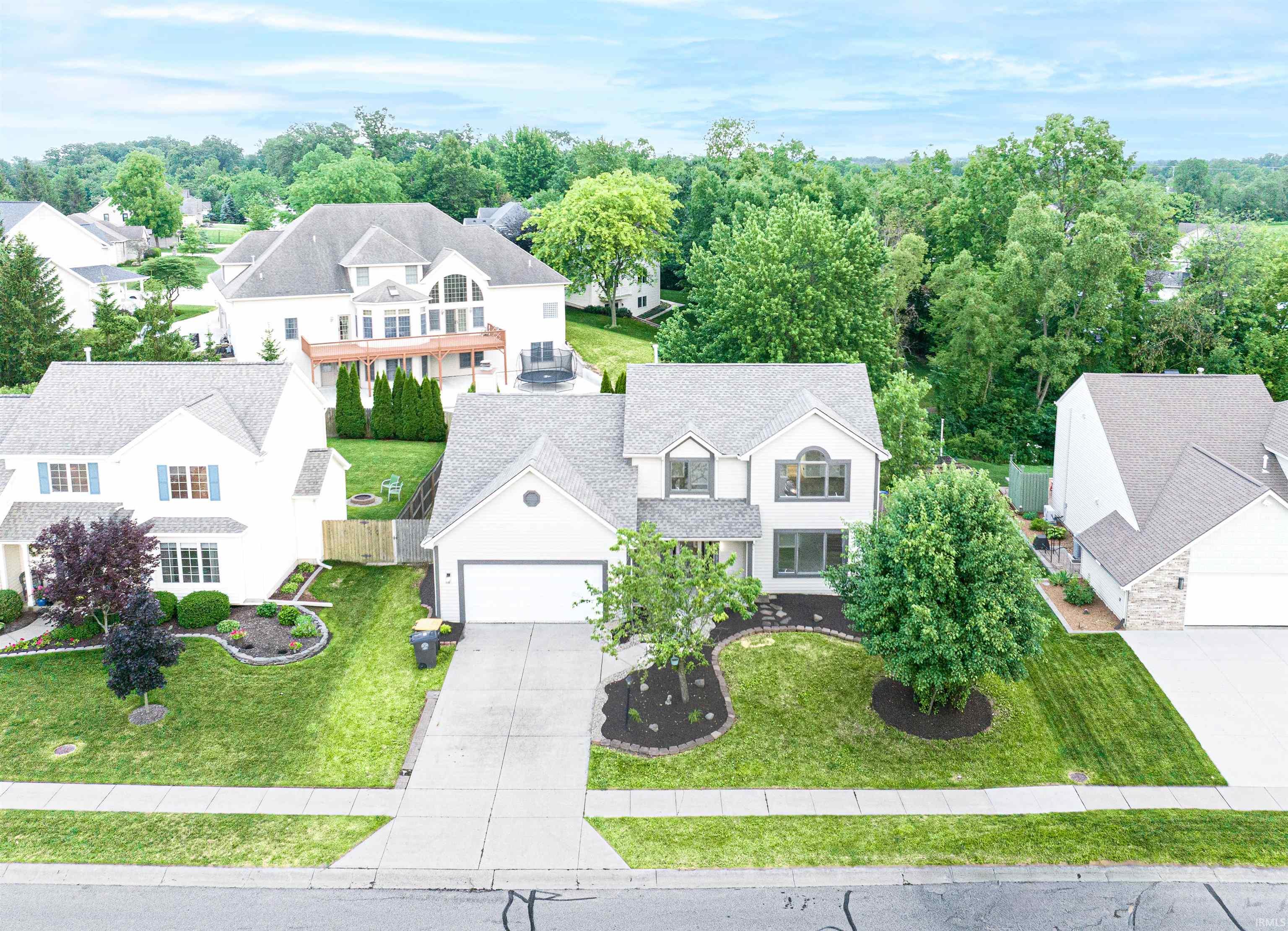 Traditional-style residence with a two-car garage and a paved driveway