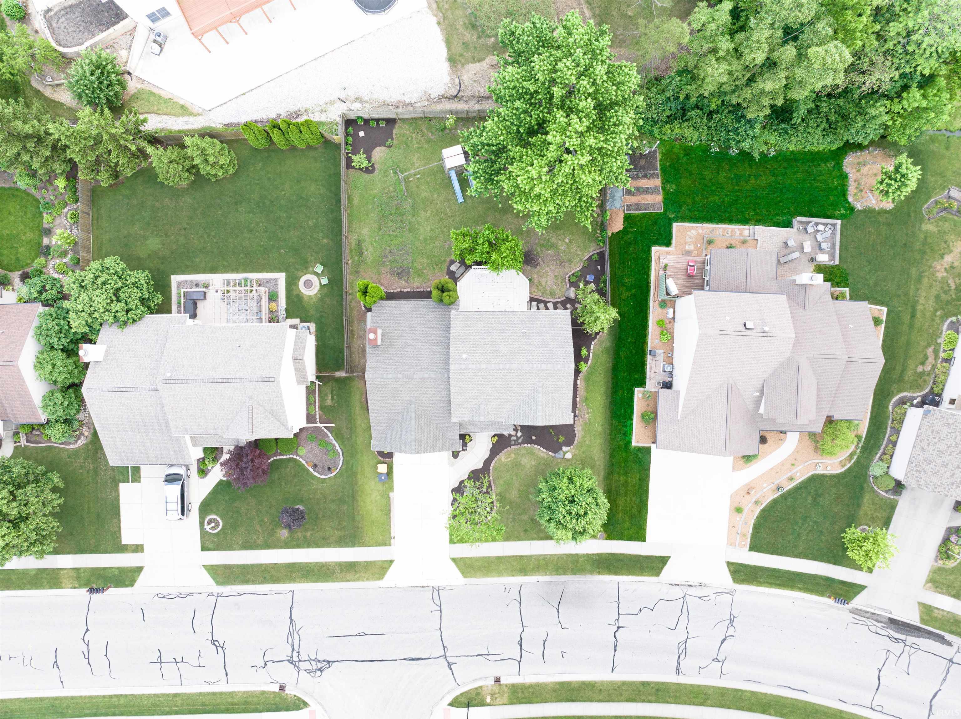 Aerial perspective showcasing three residential properties with ample green space