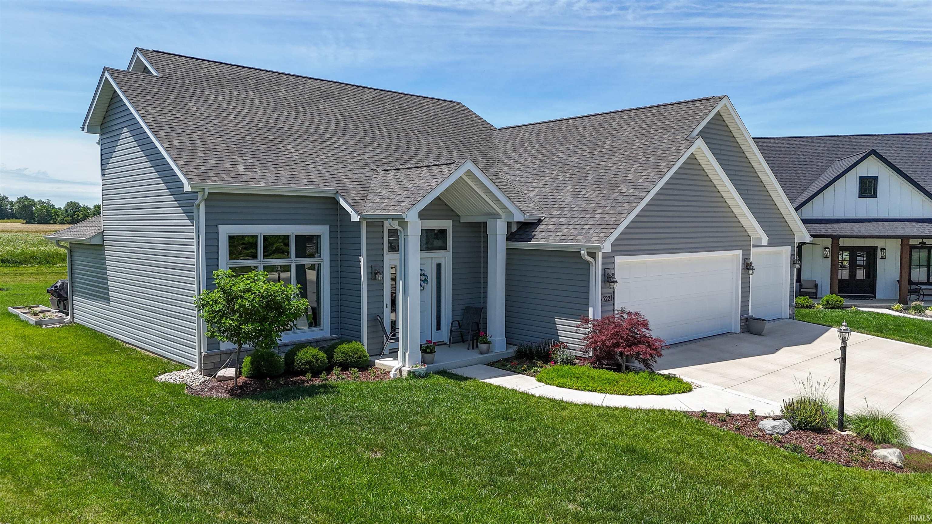Contemporary residence featuring gray horizontal siding, an attached two-car garage, and a covered entry