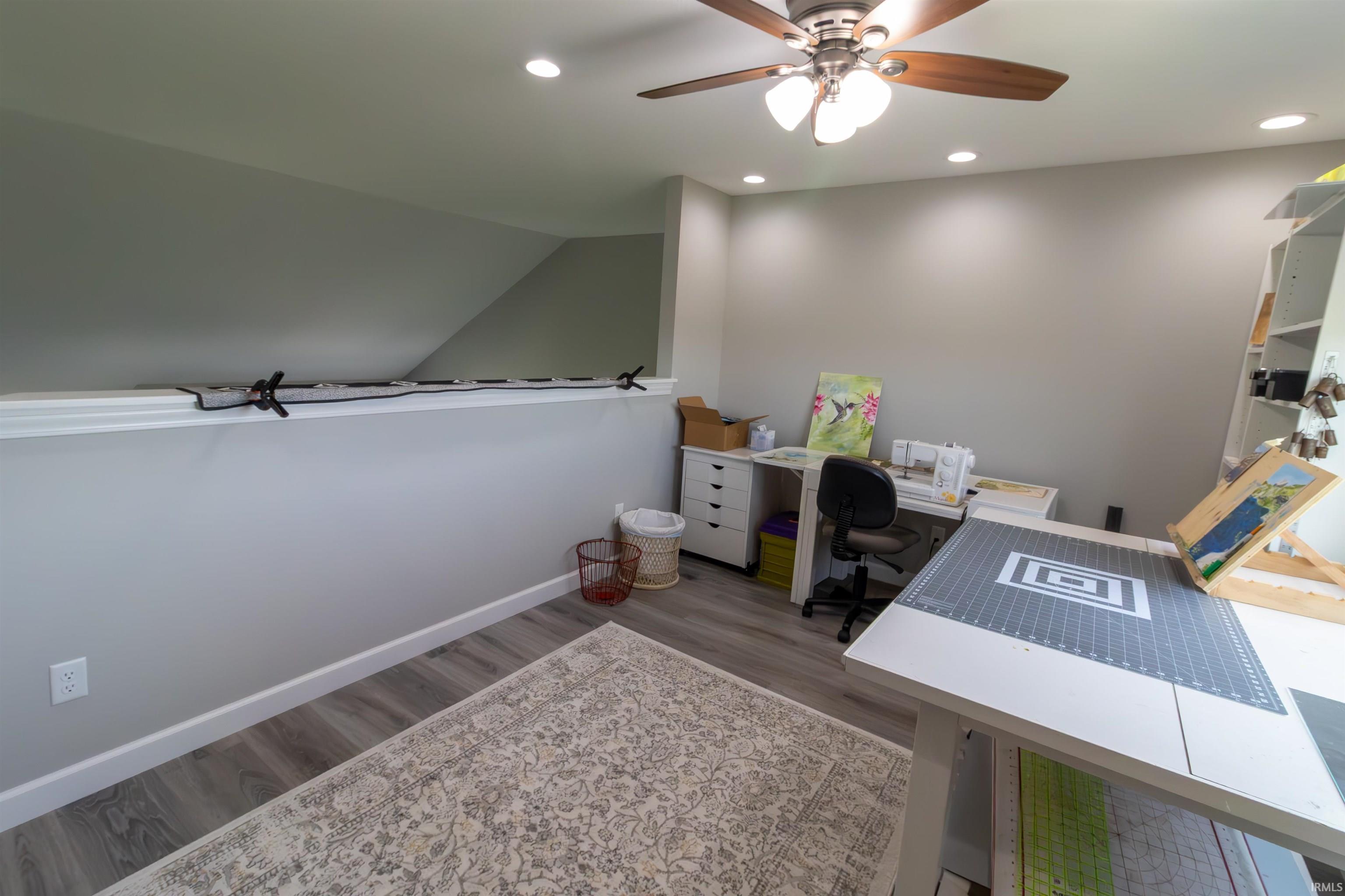 Versatile loft space featuring wood-finish flooring, recessed lighting, and a ceiling fan