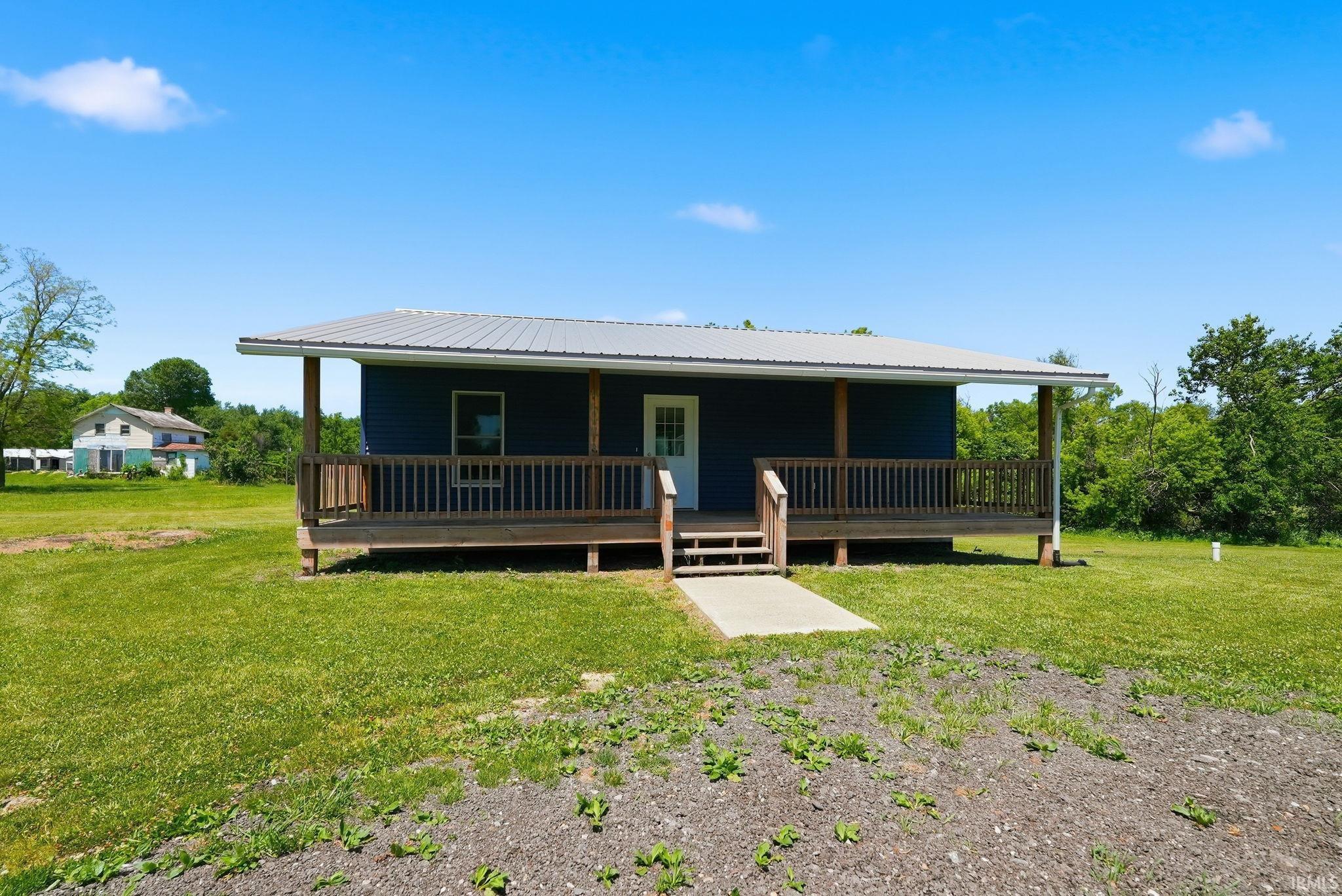 Blue siding exterior with a metal roof and a spacious covered porch