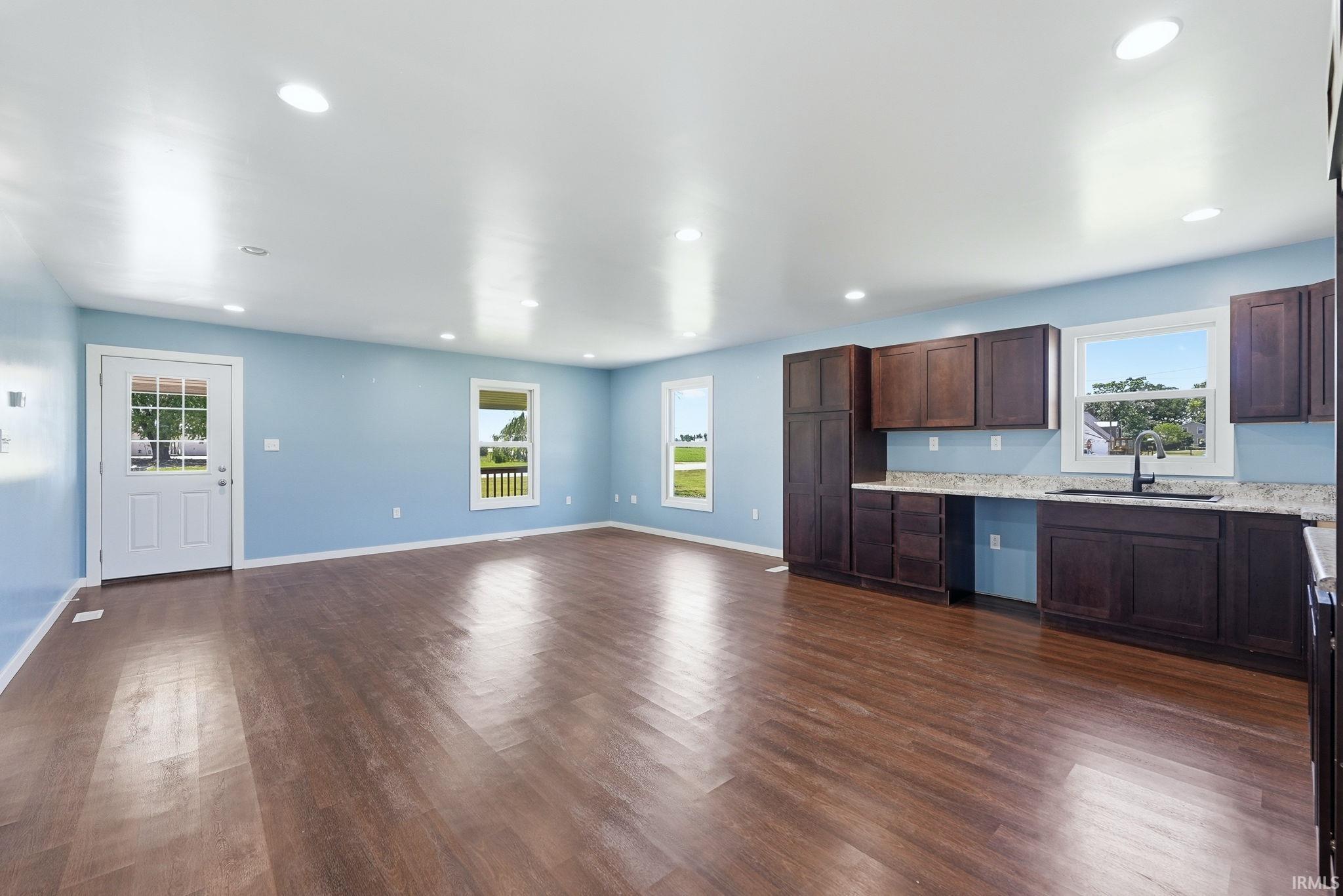 Open-concept interior featuring wood-finish flooring, recessed lighting, and light blue walls