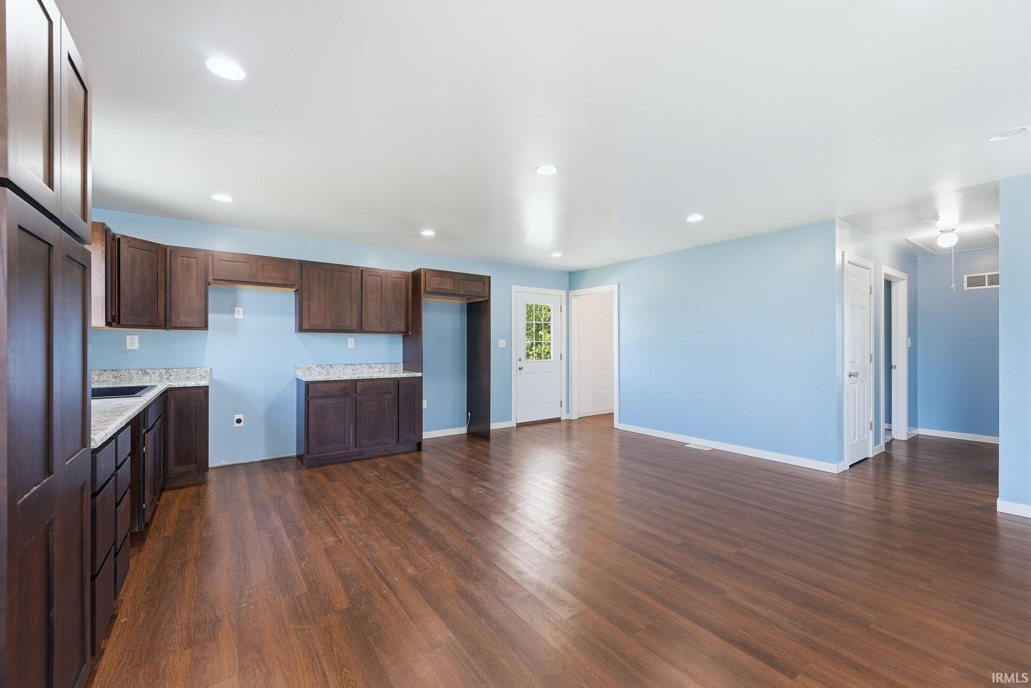 Open-concept living area featuring wood-finish flooring